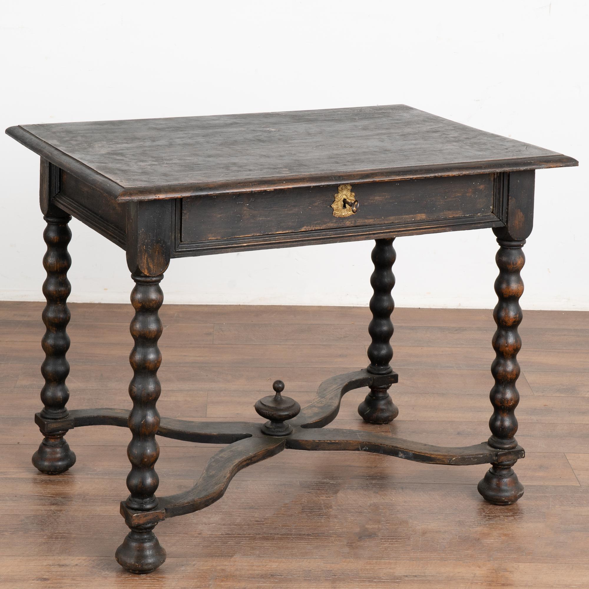 This delightful side table is a wonderful example of Swedish country craftsmanship of the early 1800's. The turned legs with X stretcher base resting on bun feet are traditional style elements while a single drawer with key (lock functions) adds