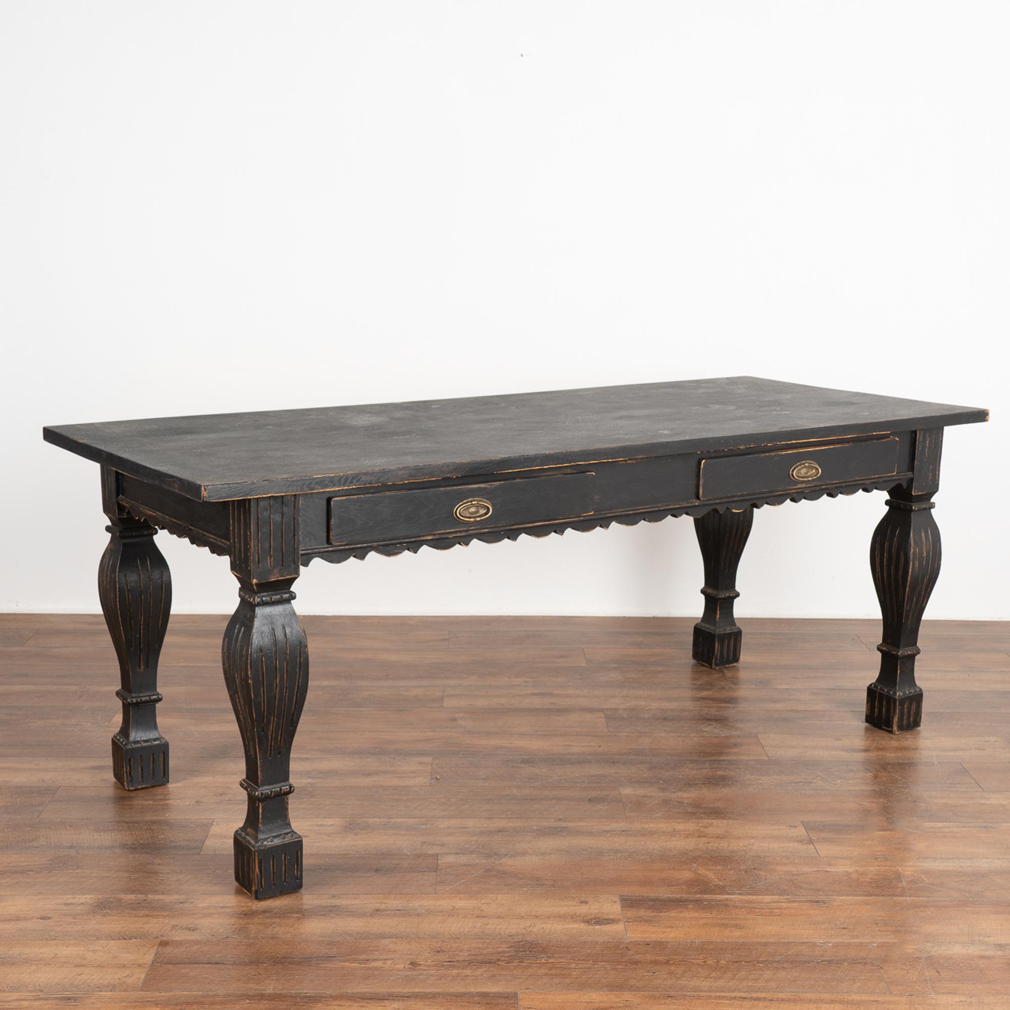 Antique baroque writing table from Denmark with two functioning drawers and scallop carved skirt.
The handsome legs with square base are made more dramatic with carved fluted trim.
Later custom painted, the black paint has been lightly distressed to