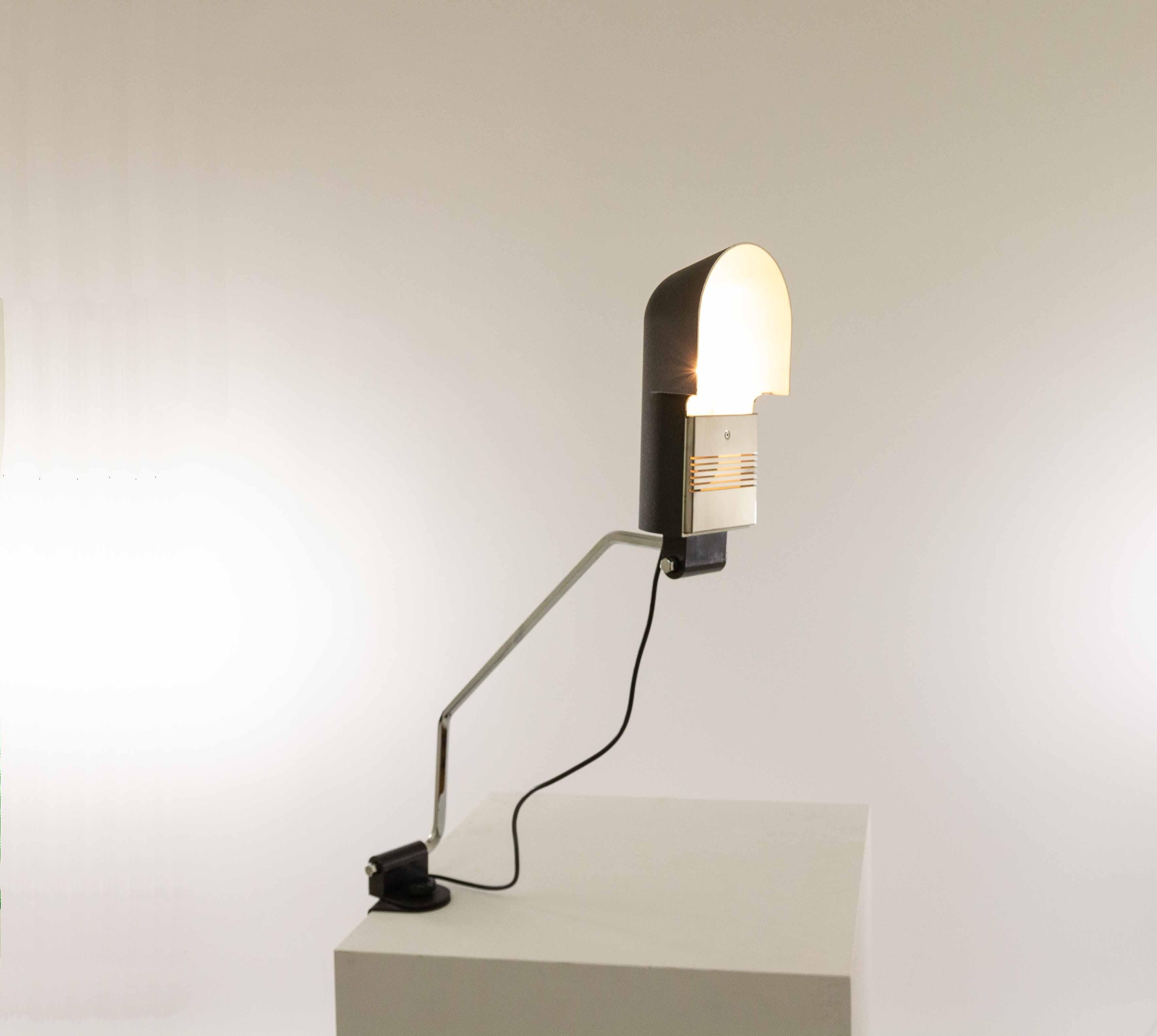 Black Pala clamp table lamp by Corrado and Luigi Aroldi for Luci, designed around 1970.

The shade is made of lacquered metal and contains a chromed steel screen. The lamp can be attached to, for instance, a desk with a clamp. This clamp contains