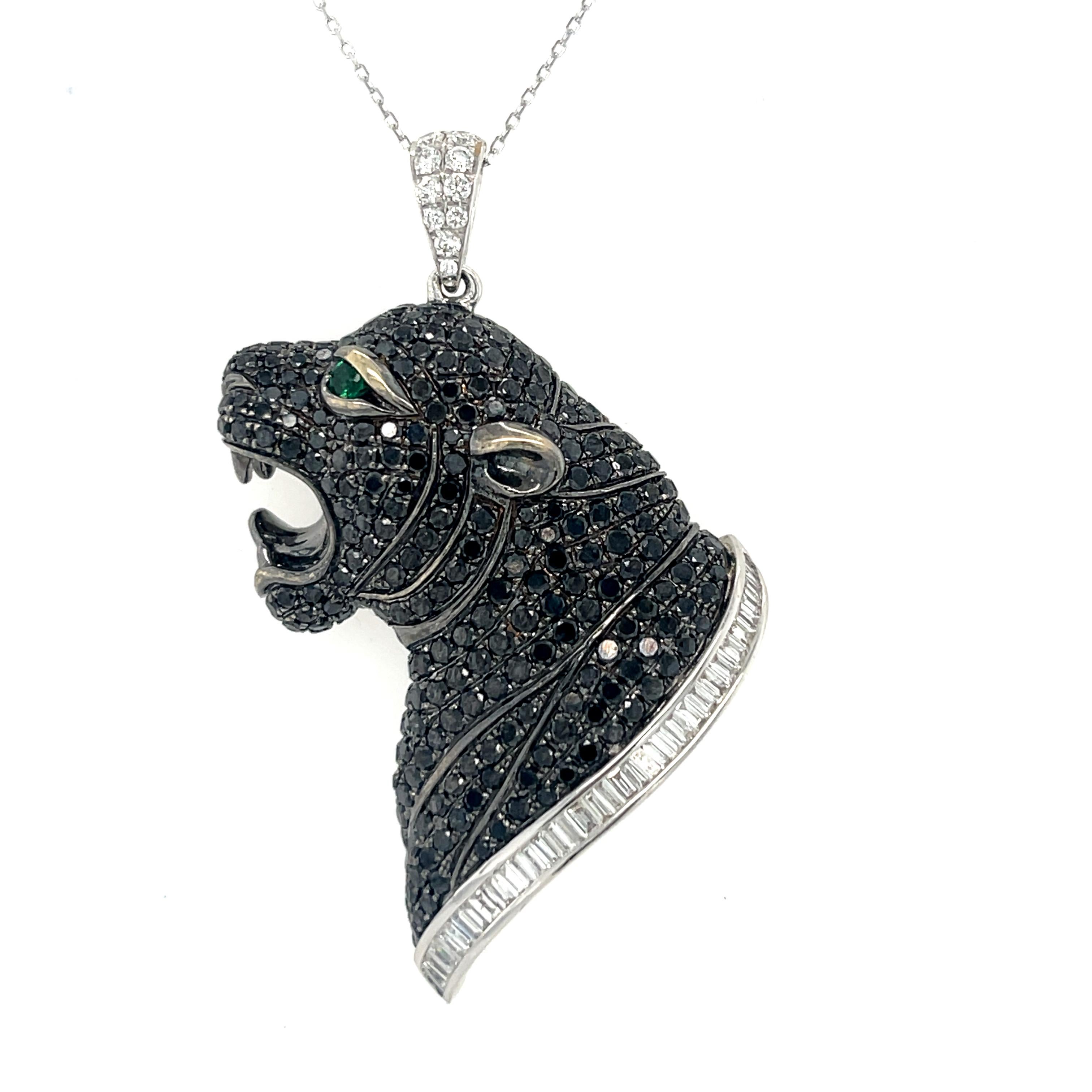 This stunning Black Panther pendant has 296 Black diamonds set in 18K White Gold. There is a natural Emerald for the eye and a row of 38 tension set White baguette diamonds. There are 10 brilliant cut round diamonds on the bale. White gold chain is