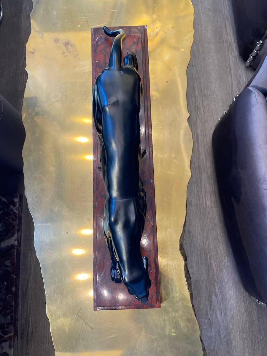Statua in bronzo nero di una pantera, firmata Noller. La statua simula il movimento dell'animale, enfatizzato dalle diverse posizioni delle zampe, appoggiate su diversi livelli della base di marmo. Le misure sono: 66 x 14 x H. 25 cm.

Il prezzo
