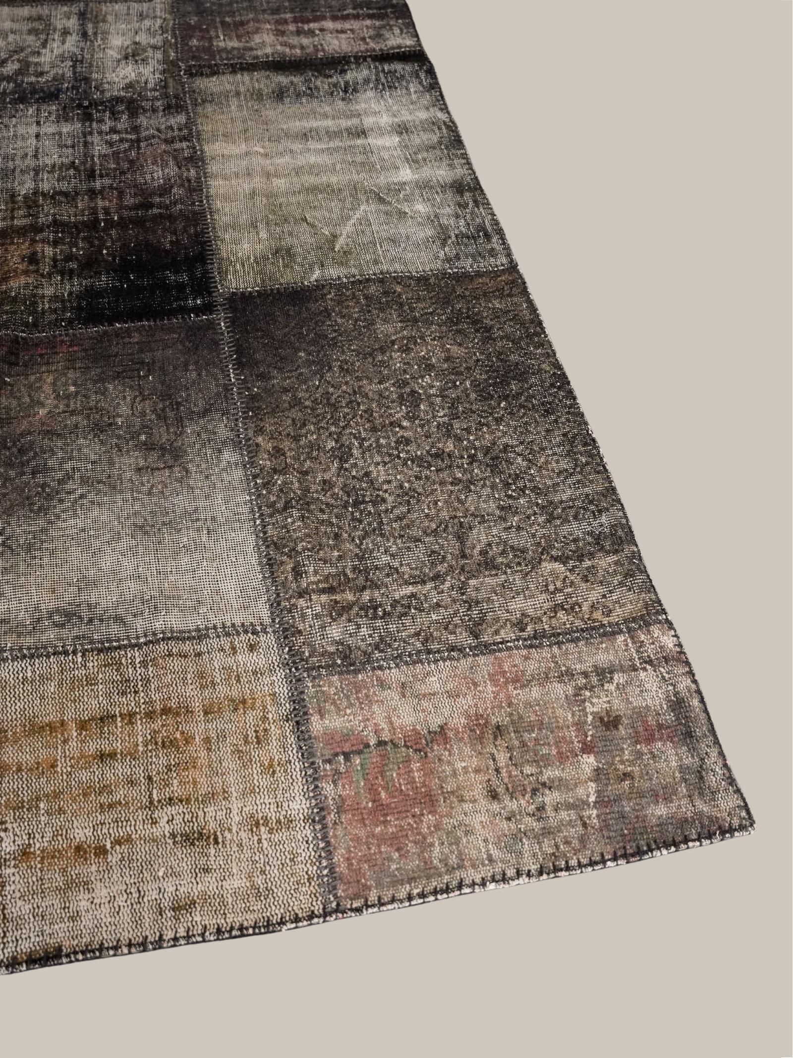La ricca storia dei tappeti kilim è ricca dell'abilità di abili tessitori che annodano a mano trame e orditi di vari colori nella caratteristica trama piatta. Questo pezzo presenta un patchwork di blocchi singoli dai toni neri e grigi, uniti per