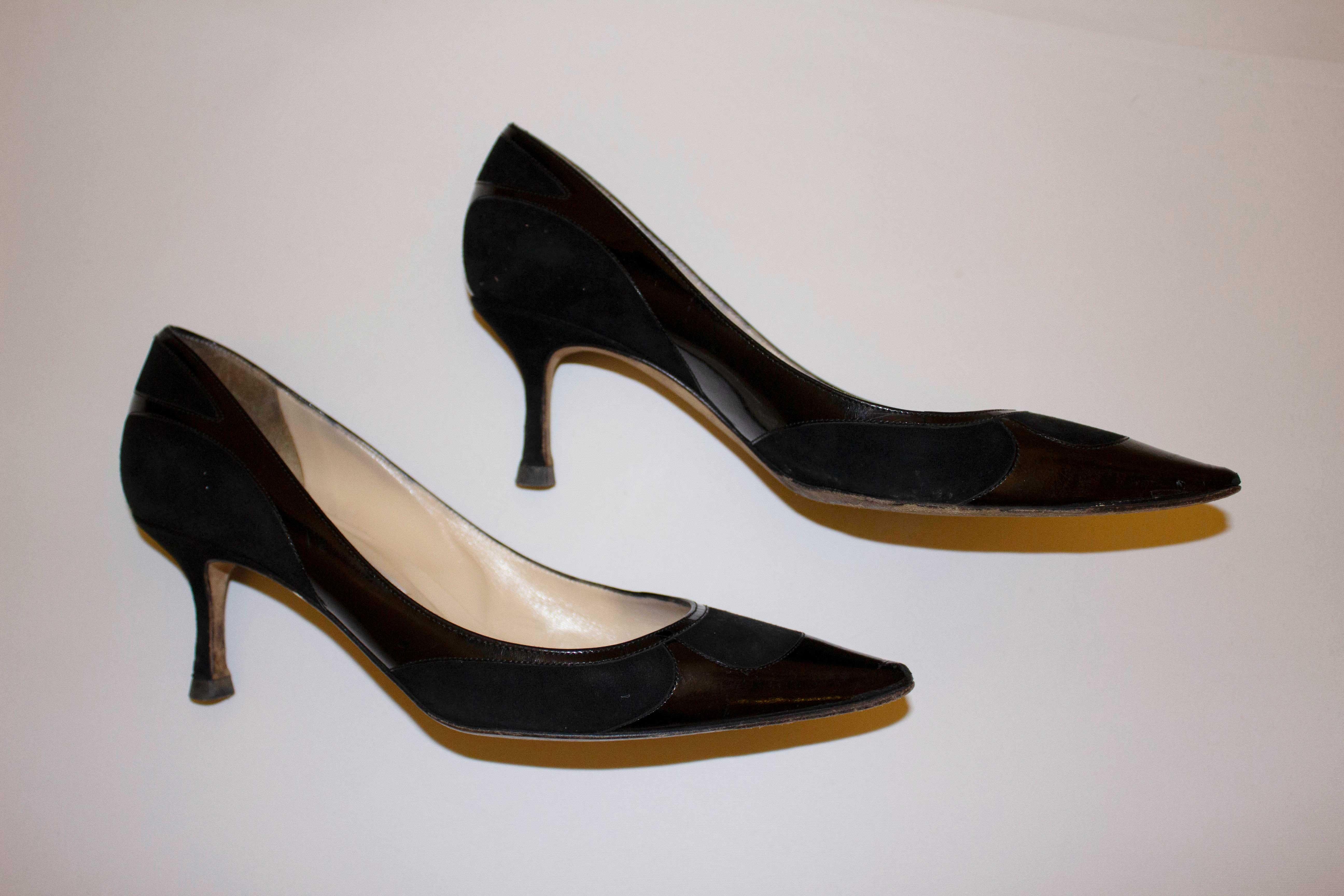 A chic pair of heels by Jimmy Choo.  In patent black leather and black suede, the heel height is
2 1/2 '' inches and size 39 1/2.