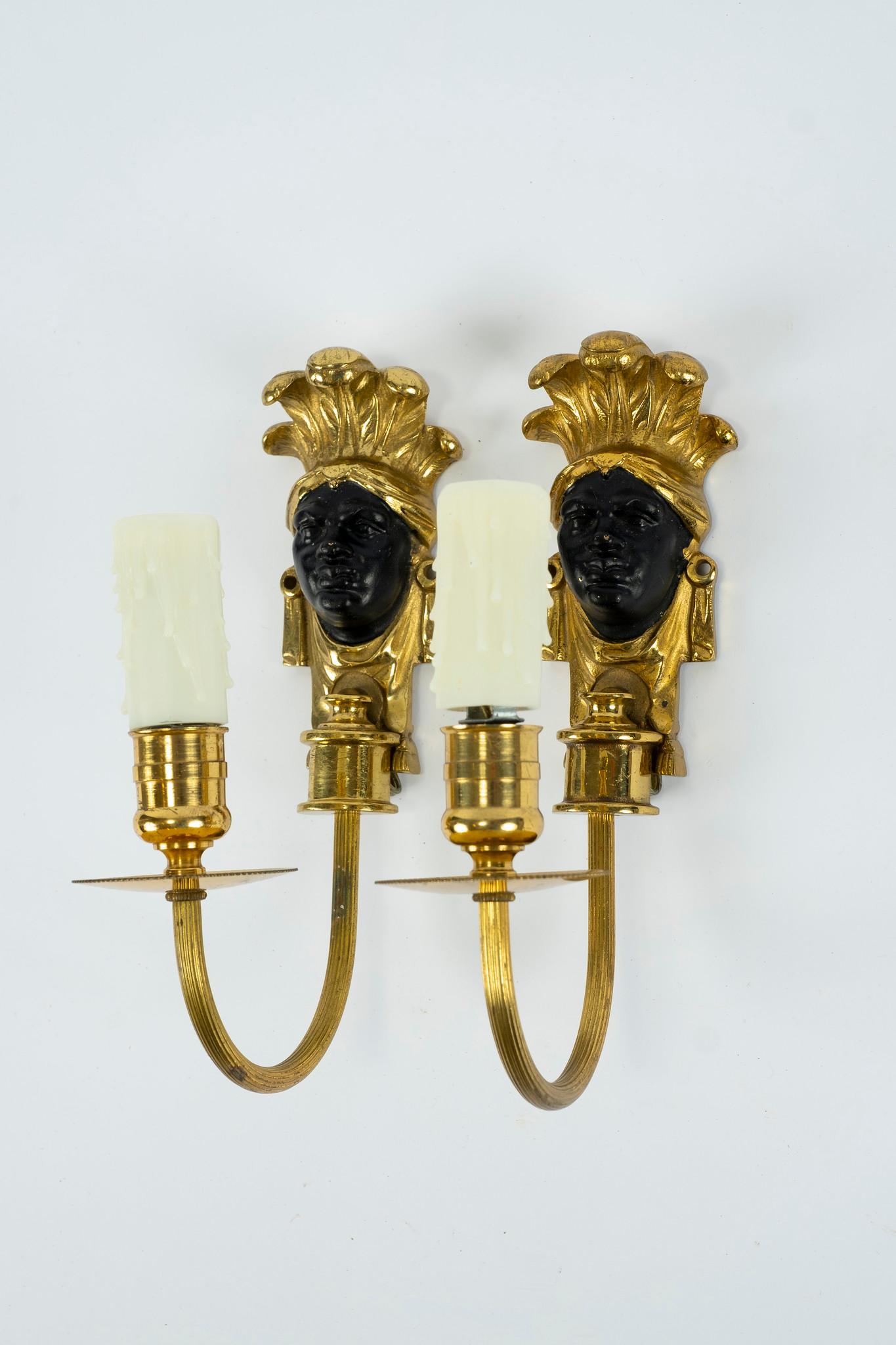 A vintage French pair of patinated brass face sconces, newly electrified.