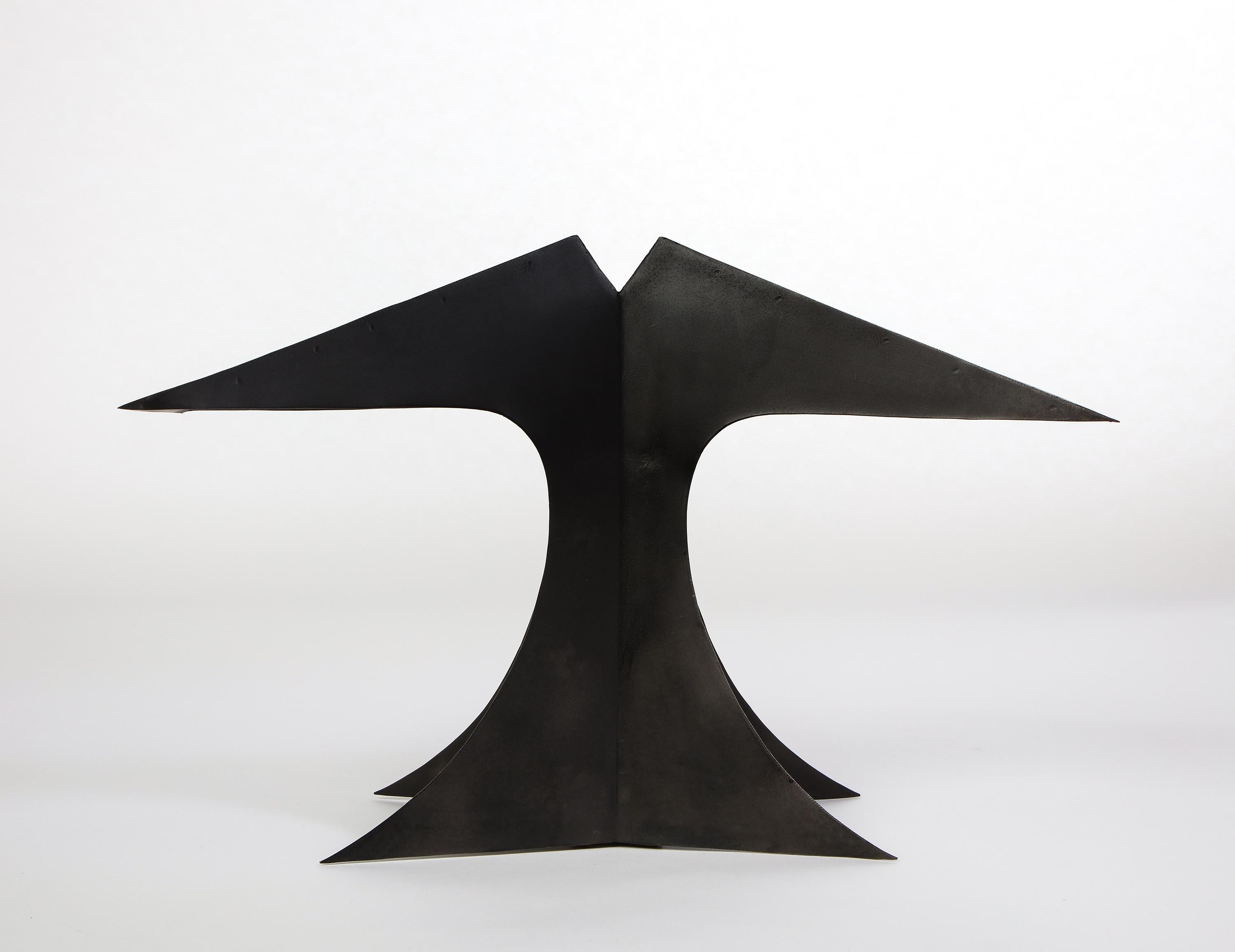 This sculptural black patinated and pierced-metal table lamp serves as a statement piece for any modernist living room. Its striking curves and angular lines make it an attractive companion for a side table or credenza. This lamp features a double