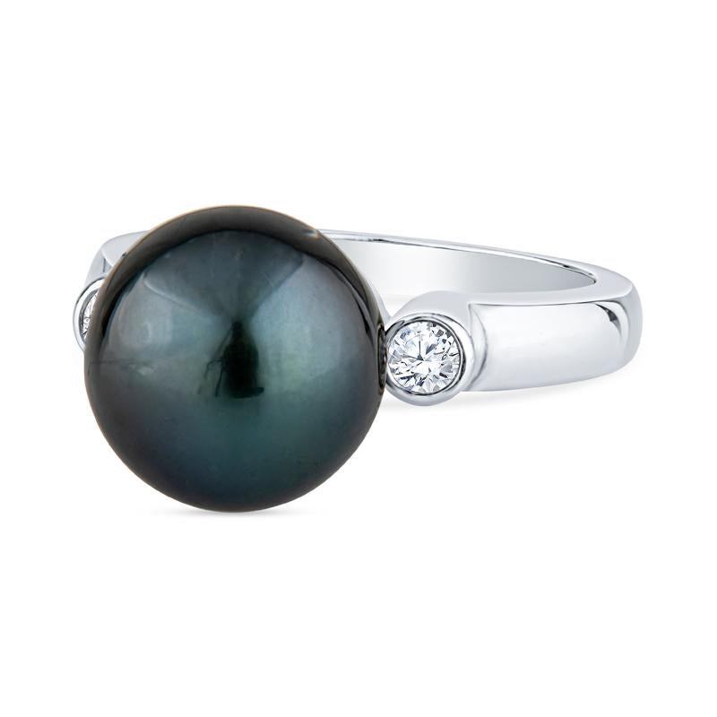 This ring features a black pearl accented by two round diamonds with a total carat weight of 0.12 carats set in platinum. It is a size 6 but can be resized upon request. 
Measurements: Pearl measures approximately 11mm