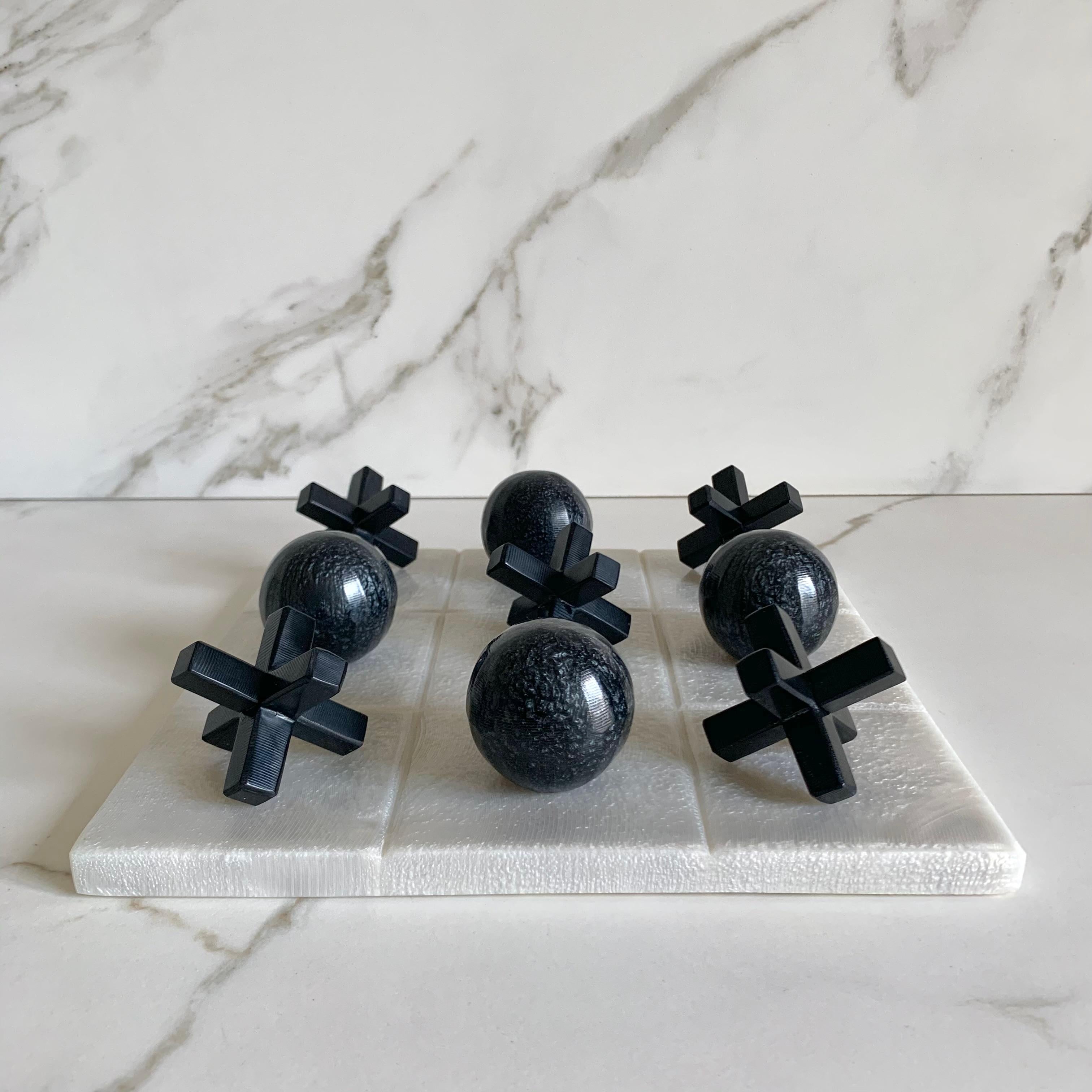 Our Tic Tac Toe is a beautiful, modern and fun take on the classic game. The three dimensional pieces are handmade in black pearl resin, and board is in white pearl resin. It will be the coolest statement piece on any coffee table.

Materials: