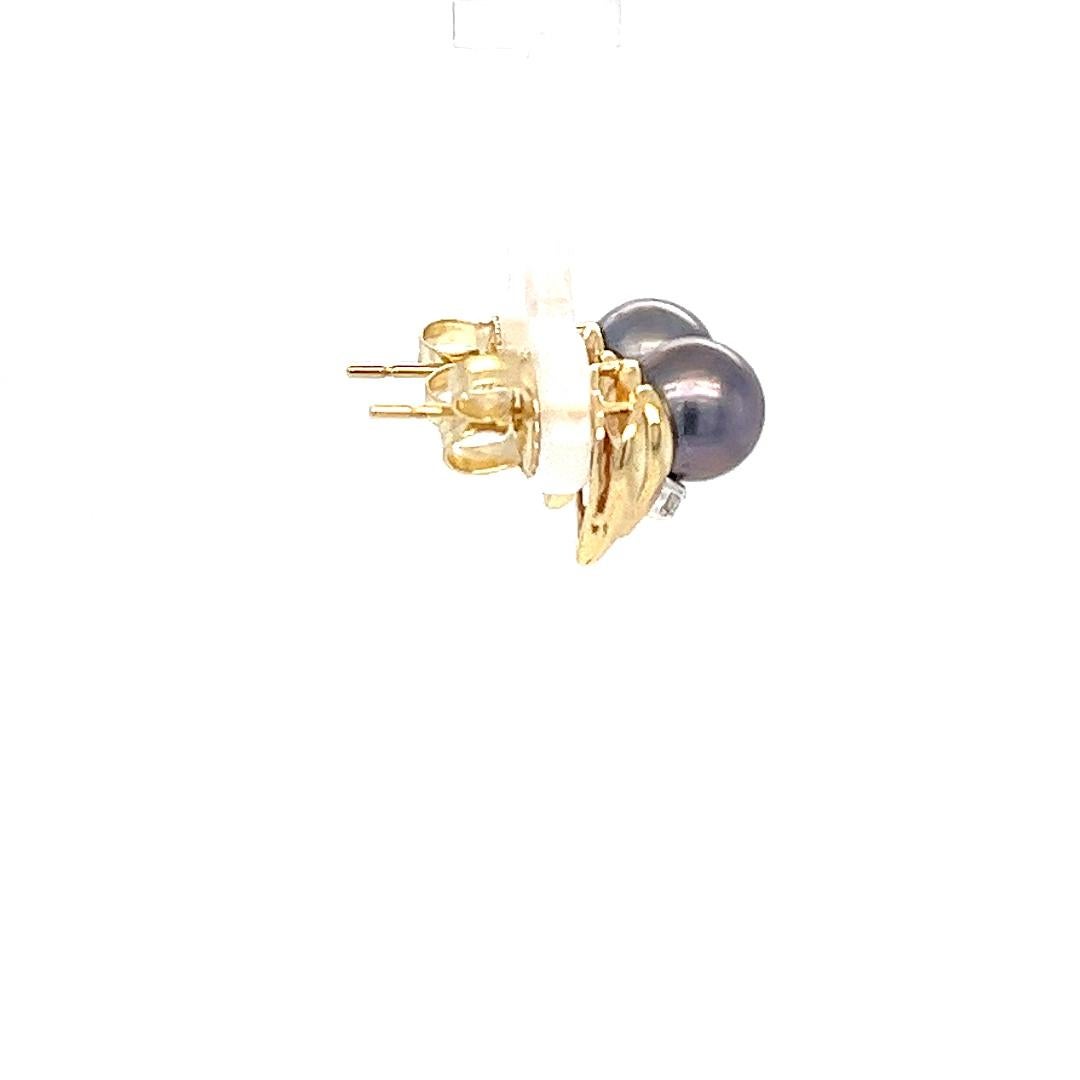 Ohrstecker aus 14 Karat Gelbgold mit zwei 7 mm großen schwarzen Zuchtperlen, die von 2 runden Diamanten von insgesamt 0,02 Karat akzentuiert werden. Durchbohrter Pfosten mit Reibungsrücken. Das fertige Gewicht beträgt 3,2 Gramm.