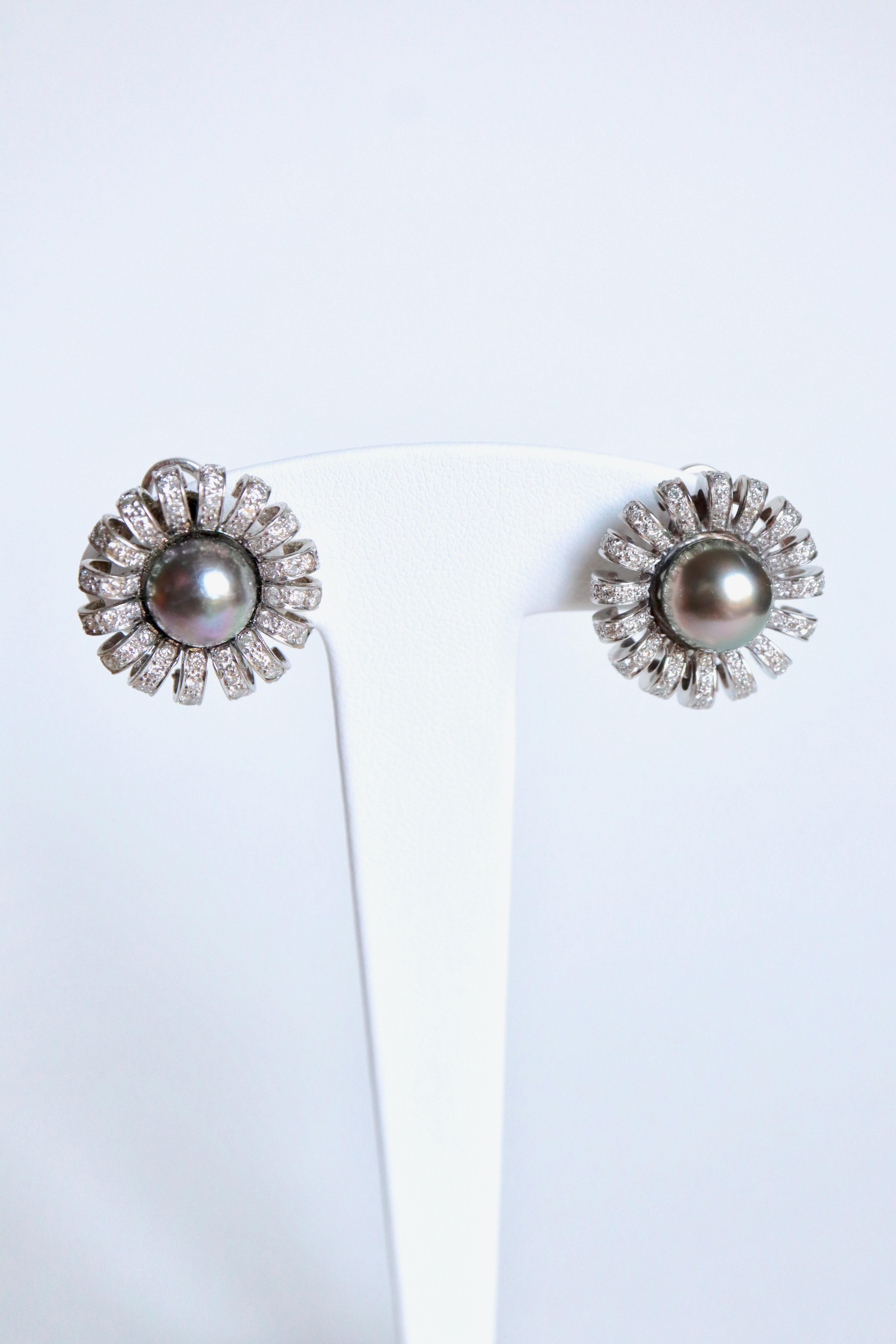 Ohrringe aus 18 Karat Weißgold, schwarzen Perlen und Diamanten. Die Perlen sind von 16 geschwungenen Blütenblättern