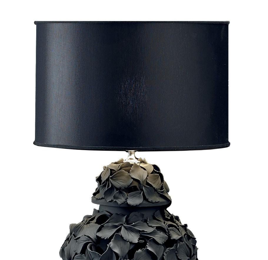 The body of this ceramic lamp features a Classic Silhouette that has been covered entirely in individual petals, each one crafted by hand and applied separately. Each petal is unique with soft lifelike curves in opaque black. When illuminated, this