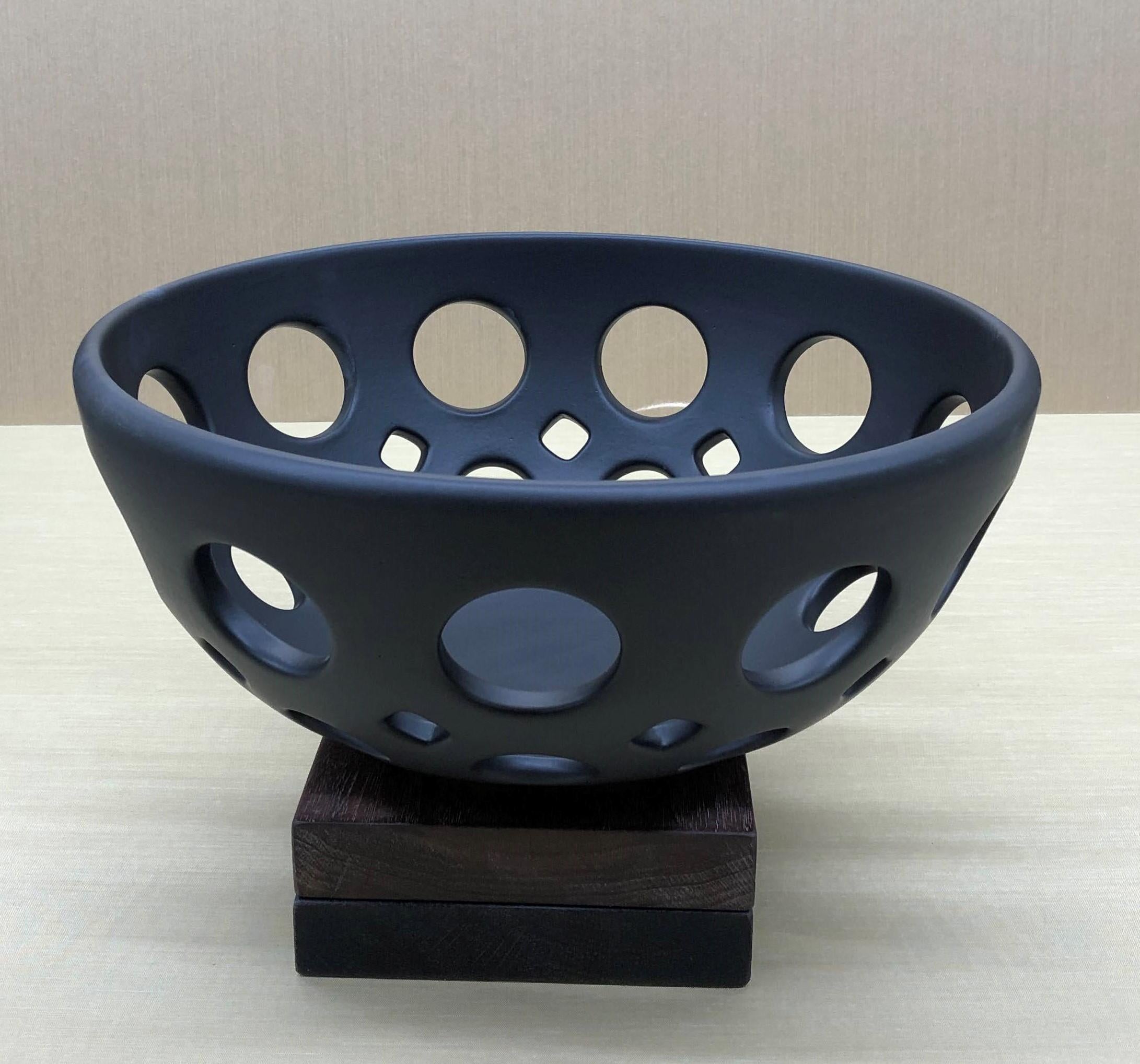 Inspired by Mid-Century Modern design, this bowl is wheel thrown and hand pierced stoneware. Small holes are created when the clay is still wet and then each hole is painstakingly enlarged and smoothed when the clay is bone dry. It is then fired