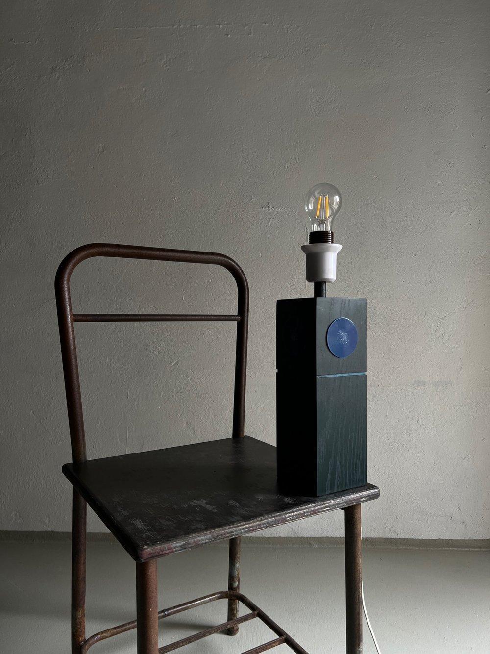 Mid-century black painted pine lamp with enameled blue decor designed by Lars-Göran Nilsson and Ewa Wrangel for Ateljé Glas & Trä. This lamp comes without shade.

Dimensions: H (wooden part/incl bulb) 28.5/40 cm, D 10 cm.