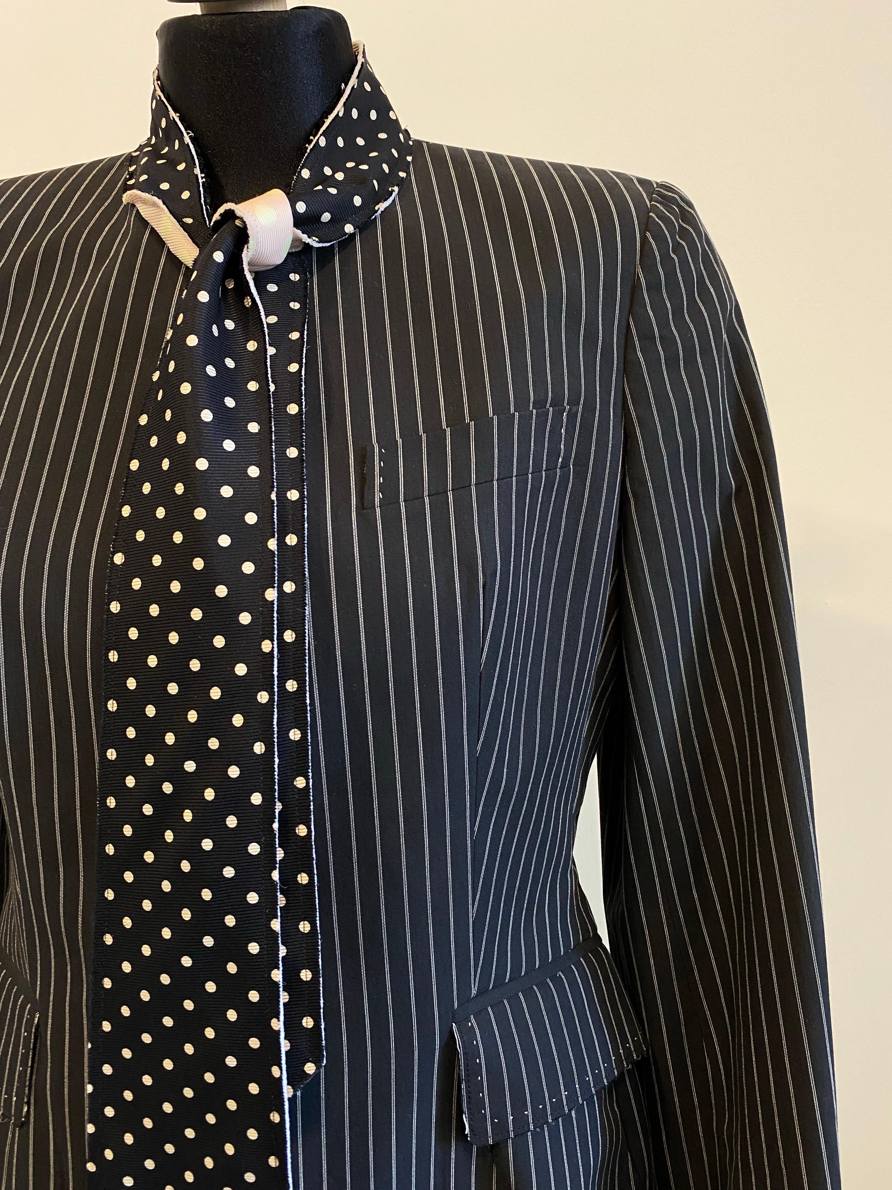 Black pinstripe Paul Smith tuxedo jacket with built-in bow tie, black with white polka dots on the front and pink with white polka dots on the back, to be tied at will.
Uncovered button closure.
The jacket is deliberately unfinished tailoring.
Size