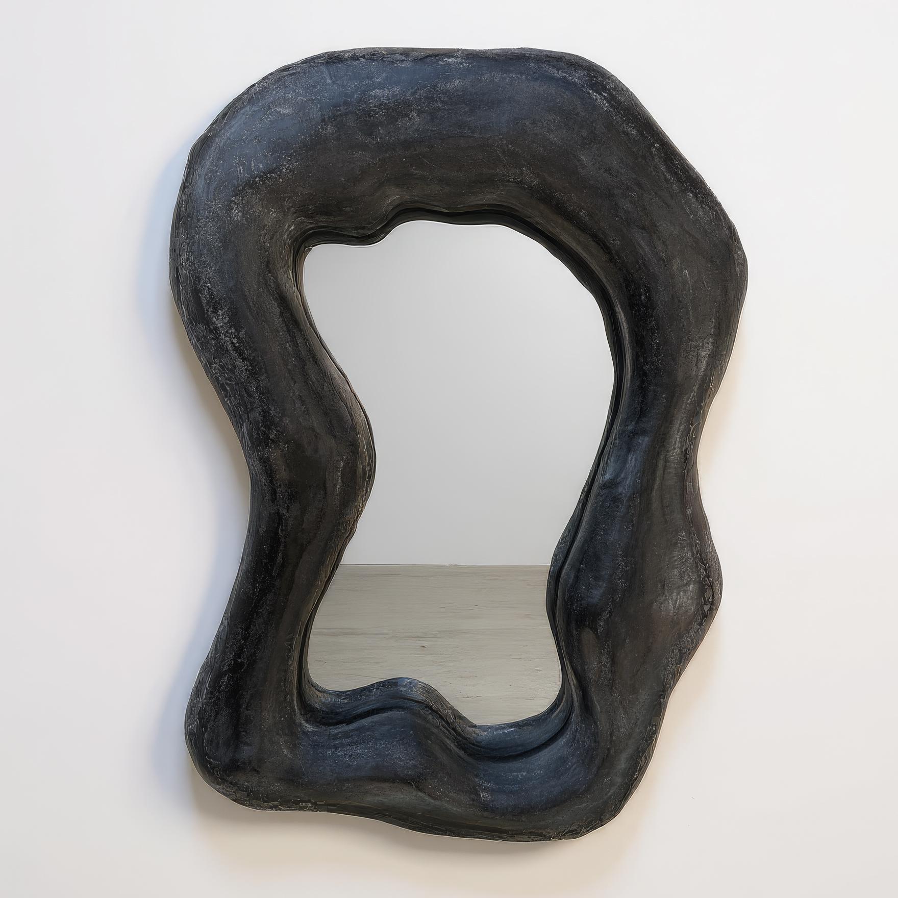 Handcrafted with Venetian plaster, this sculptural mirror features a deep black finish with a rich, tactile texture. The organic, fluid form invites both reflection and contemplation, while the hand-burnished and waxed surface adds depth and a