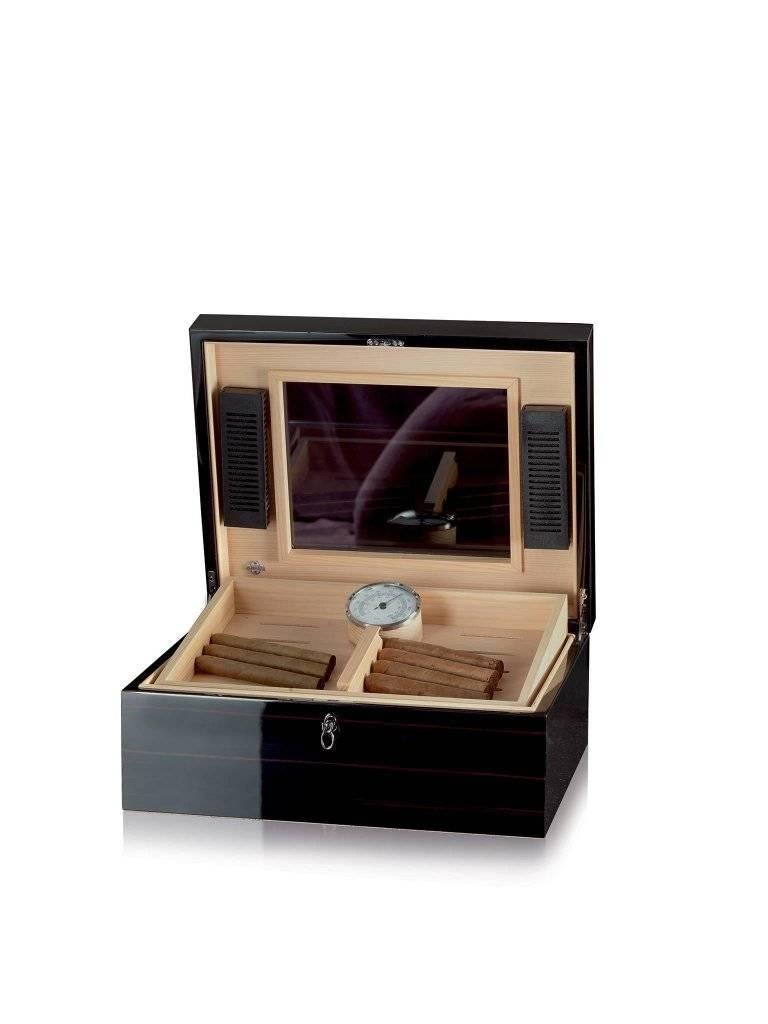 Polished wooden humidor with tray. Cedar lined. Ruthenium-plated hardware. High class for the happy few.