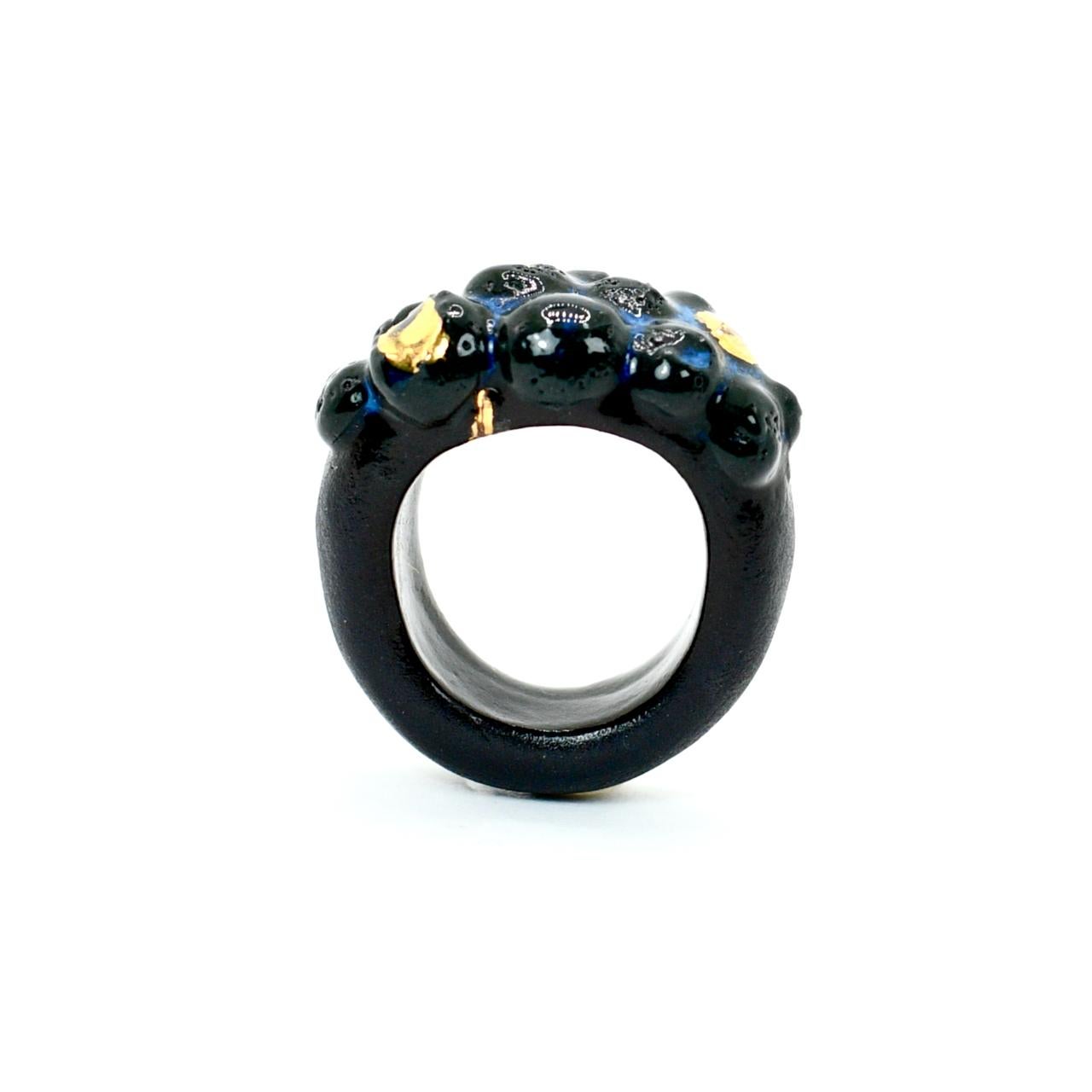 Black porcelain  24K gold  Handmade in London 

Introducing the DIRION Black Porcelain Ring - a wearable sculpture of black onyx porcelain and 24k gold. The sculptural surface, adorned with a blue glaze, evokes the beauty of rivers flowing between