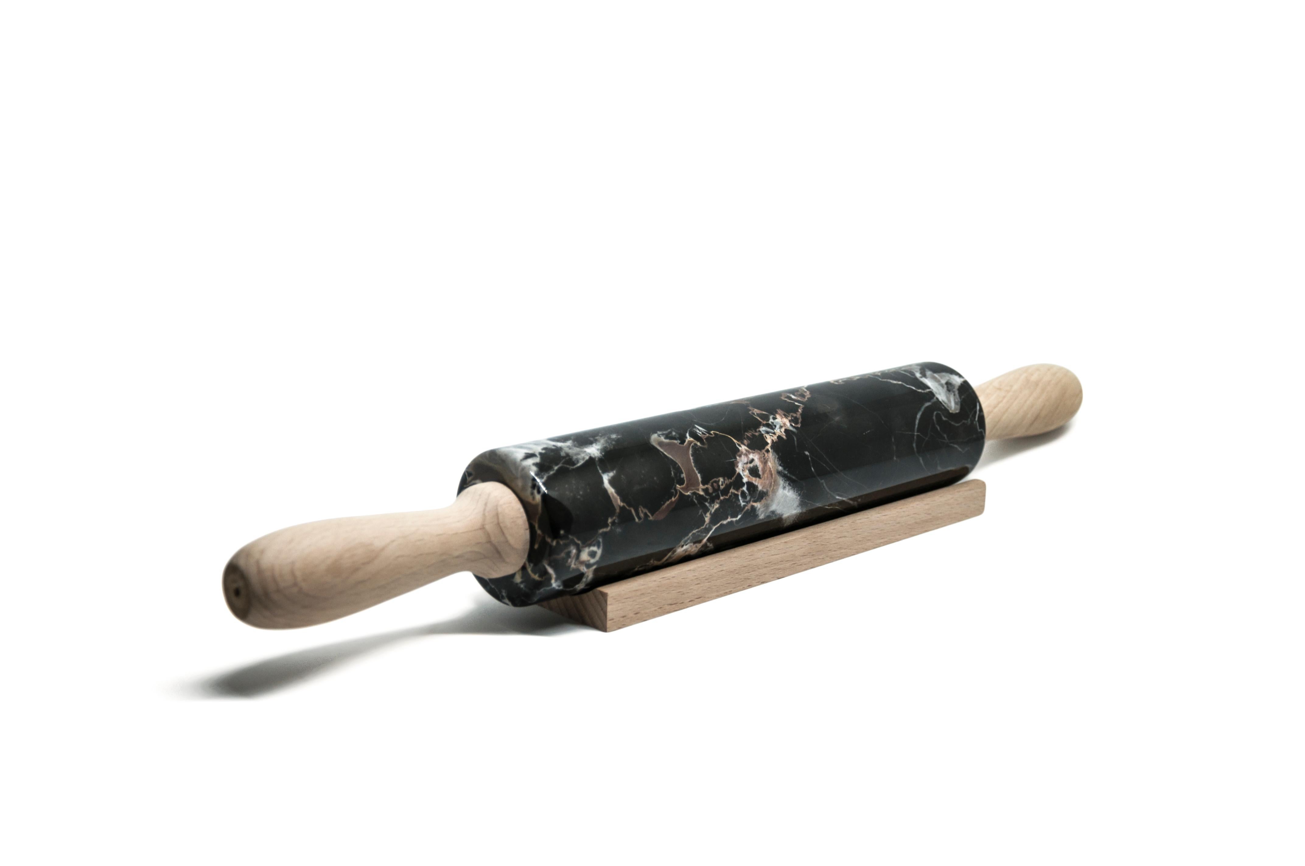 Portoro marble rolling pin with wooden handles. It is assembled manually. Each piece is in a way unique (every marble block is different in veins and shades) and handmade by Italian artisans specialized over generations in processing marble. Slight