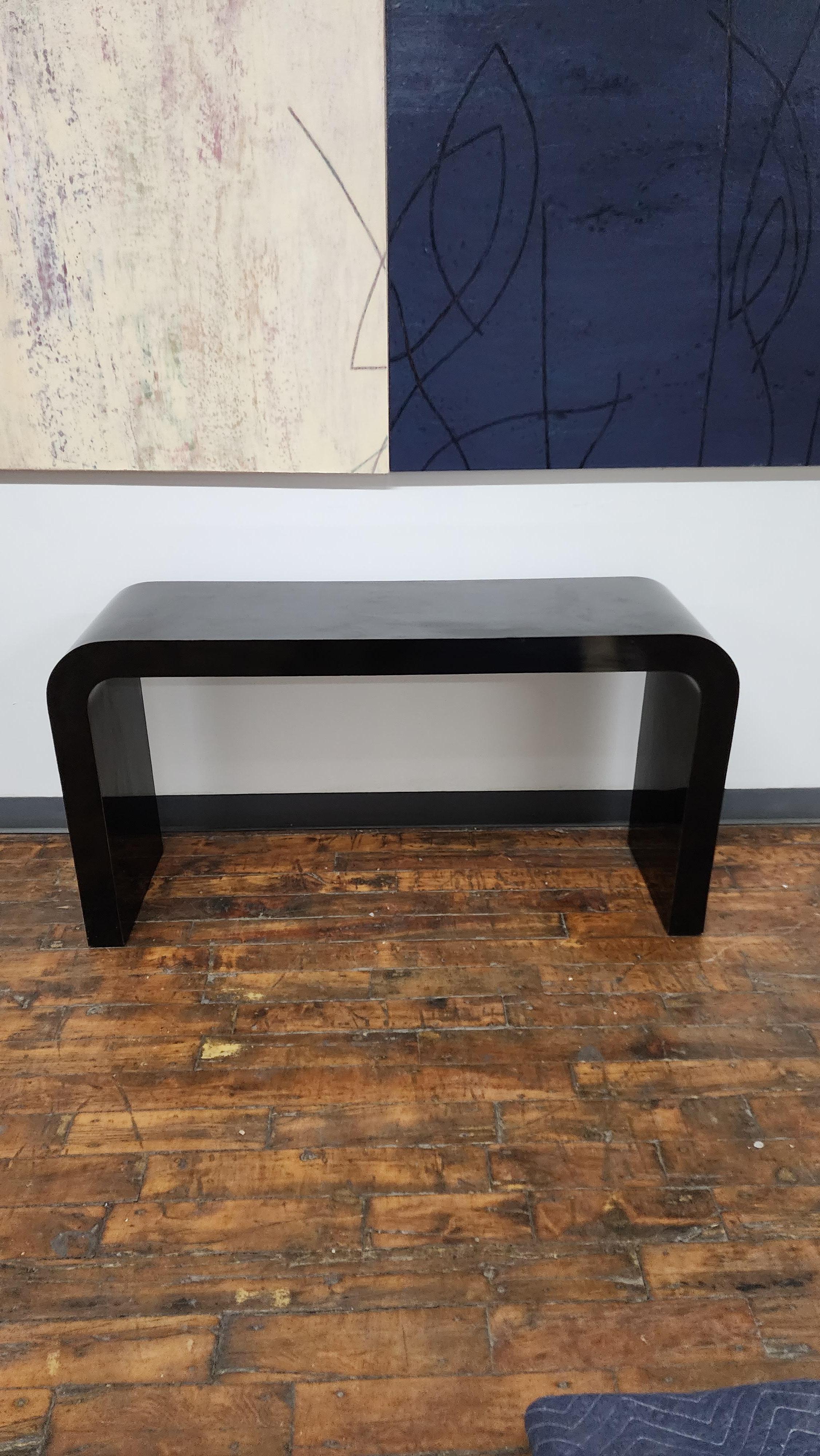 Great post modern gloss black waterfall console table.  The black post modern table would go great with many styles.