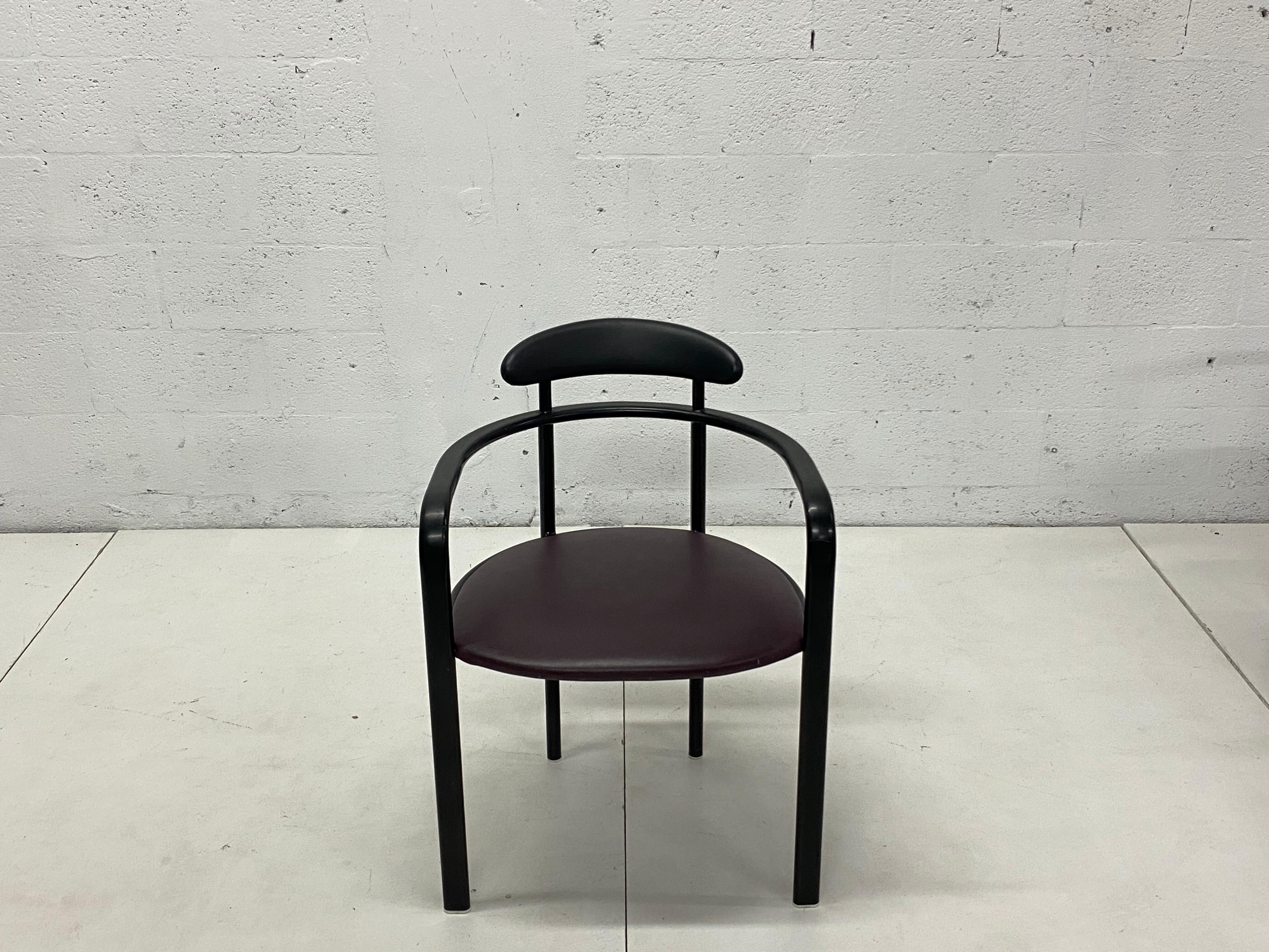 Postmodern dining chairs by Hank Loewenstein circa 1980s. The black enamel steel frame supports a purple vinyl cushioned seat and black foam backrest. Use with existing vinyl fabric or have reupholstered.

Two chairs remain available.