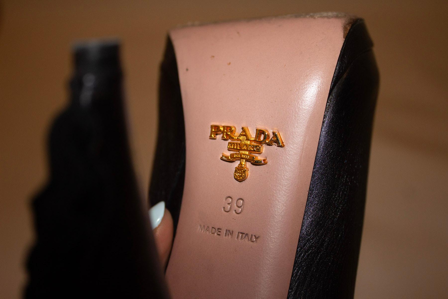 Un fantastico paio di stivali di Prada. In pelle nera con punta a mandorla e apertura a zip. L'altezza del tacco è di 5'', decorato con un volant in pelle. Prodotto in Italia. Taglia 39