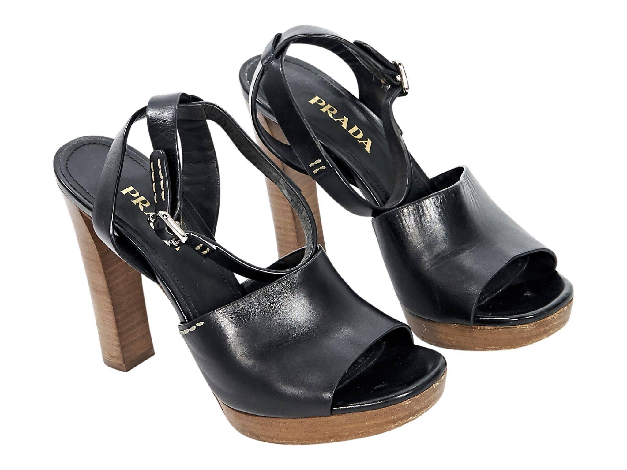 Product details:  Black leather platform sandals by Prada.  Adjustable ankle strap.  Open toe.  Towering stacked heel and platform design. IT size 38.5
Condition: Pre-owned. Very good. 
Est. Retail $795