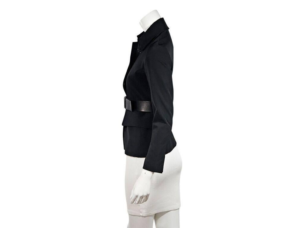 Product details:  Black nylon belted jacket by Prada.  Spread collar.  Bracelet-length sleeves.  Concealed button-front closure.  Adjustable belted waist.  Waist flap pockets.  Label size IT 38.  34