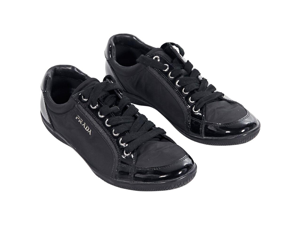 Product details:  Black nylon sneakers by Prada.  Trimmed with patent leather.  Lace-up closure.  Round toe.  
Condition: Pre-owned. Very good.
Est. Retail $ 695.00