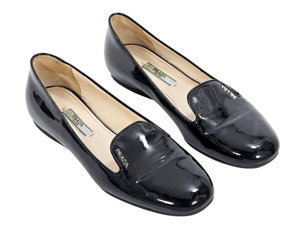 Product details:  Black patent leather low wedge loafers by Prada.  Round toe.  Slip-on style.
Condition: Pre-owned. Very good. 
Est. Retail $ 585.00
