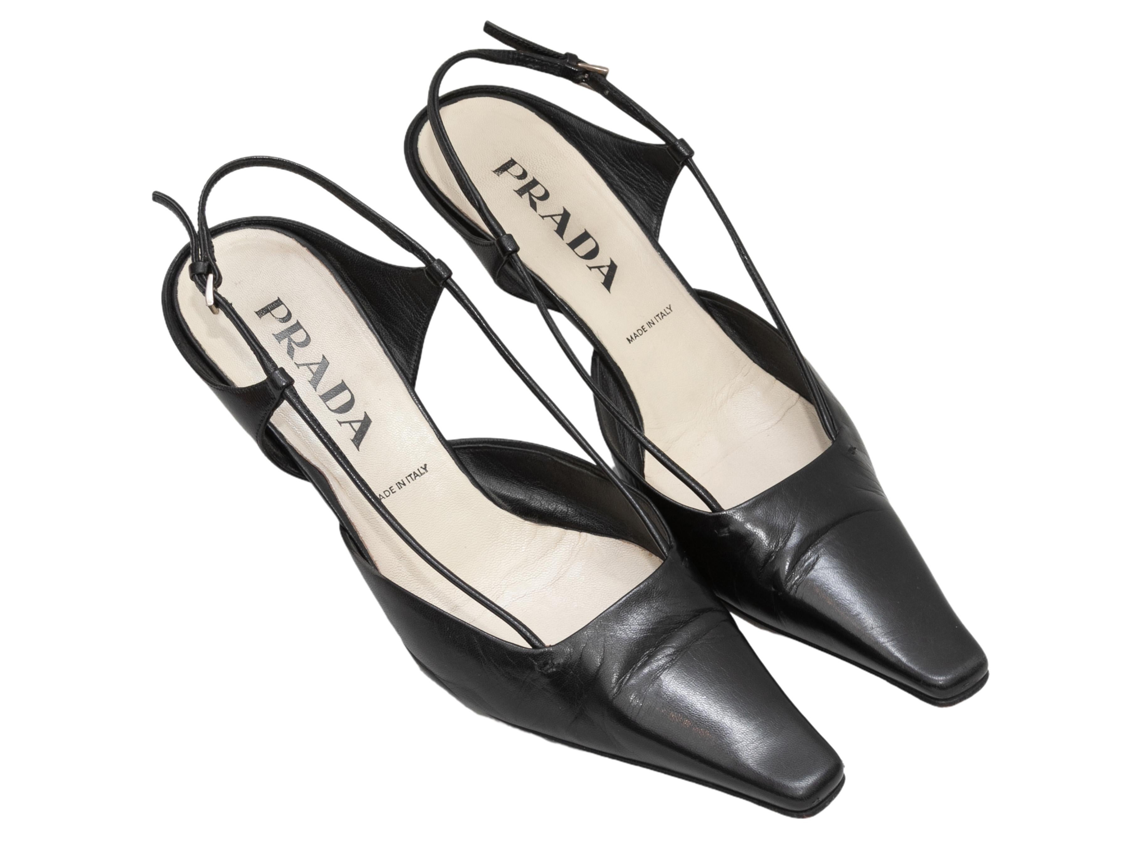 Black leather pointed-toe slingbacks by Prada. Kitten heels. Buckle closures at slingback straps. 2.25