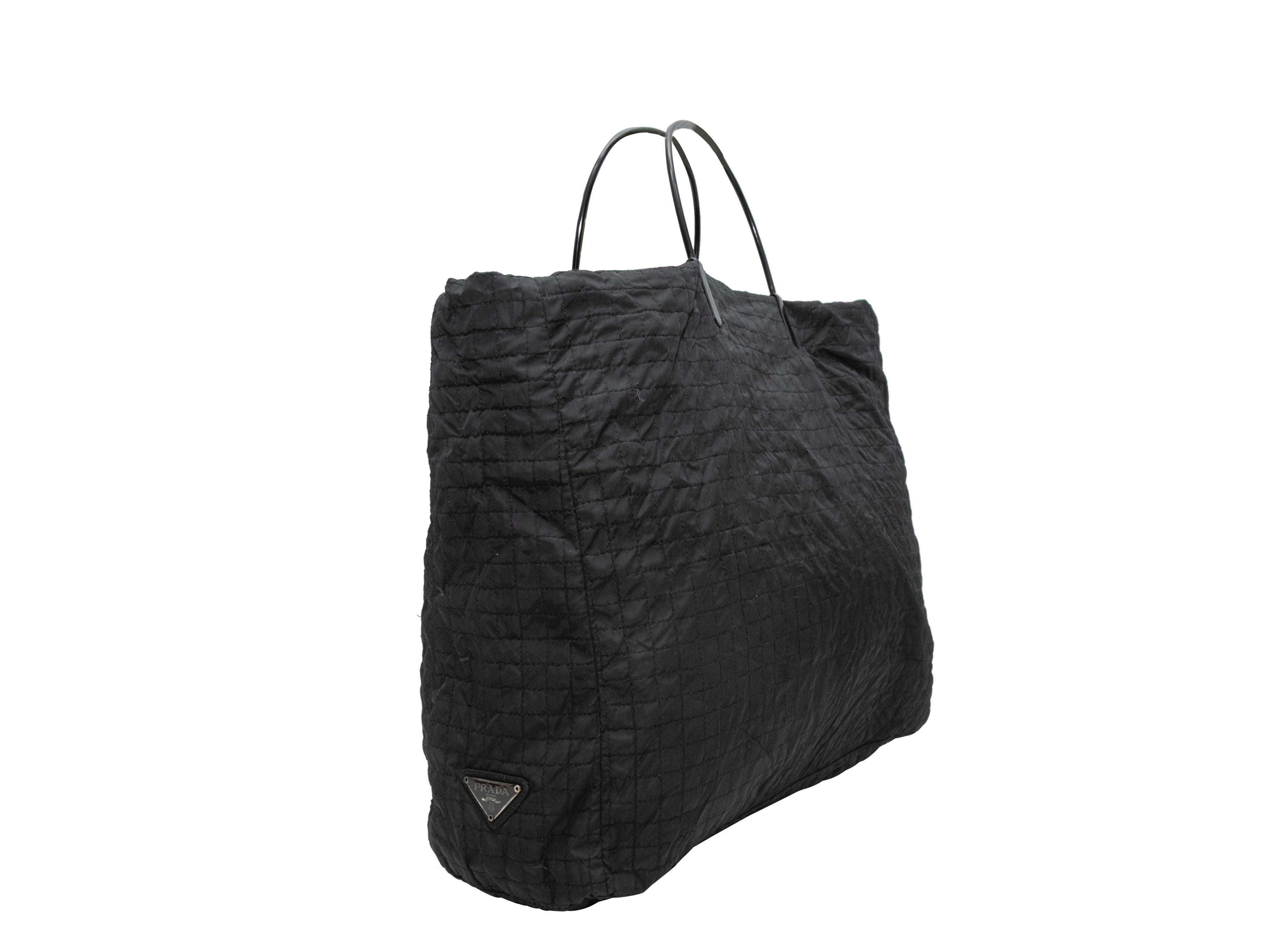 Black Prada Quilted Nylon Tote Bag. This tote bag features a nylon body, dual plastic top handles, and a top zip closure. 18