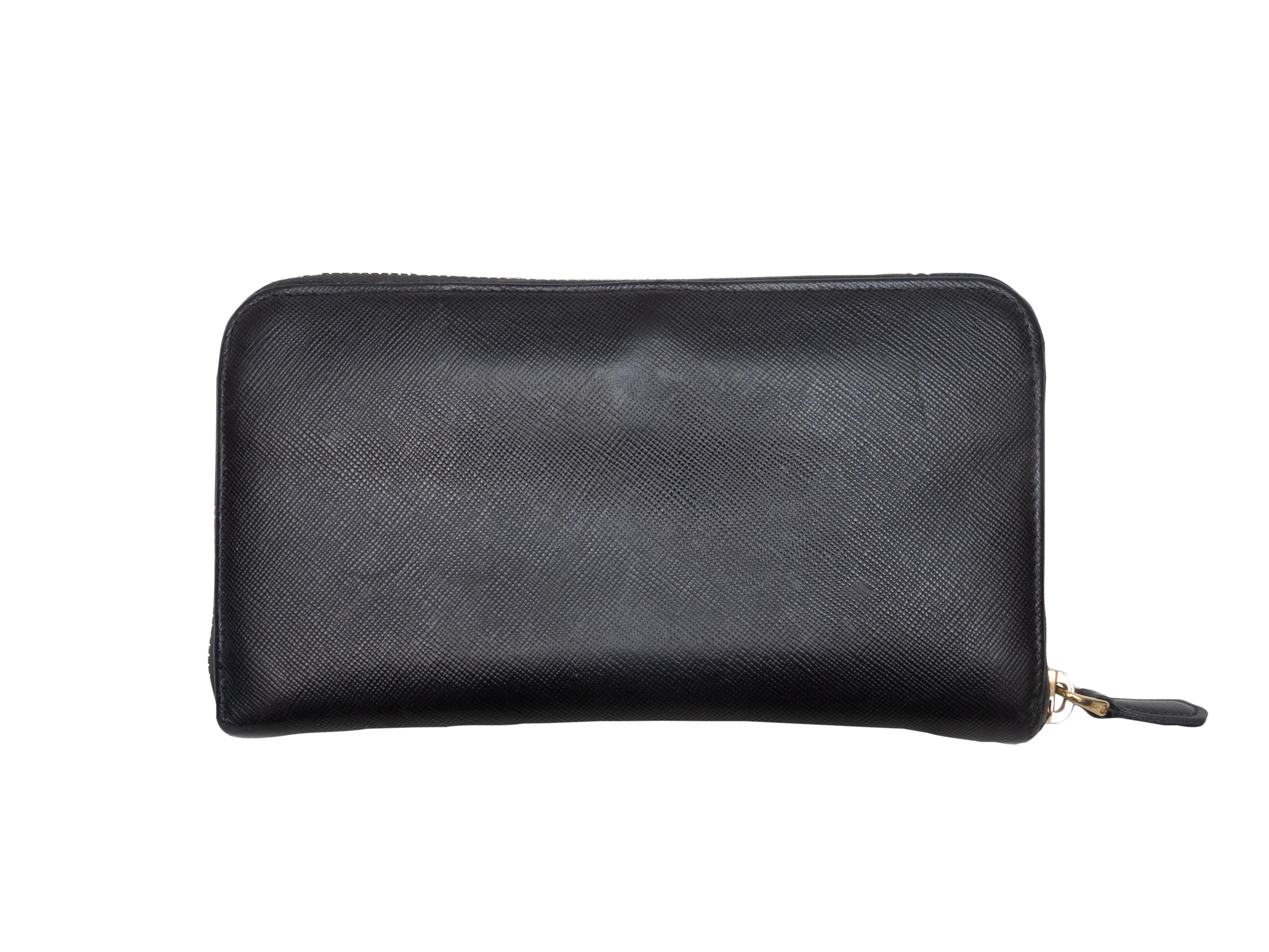Portafoglio continentale in pelle saffiano nera di Prada. Hardware in tonalità oro. Slot interni per carte e contanti. Chiusura con zip in alto. Altezza 4,25