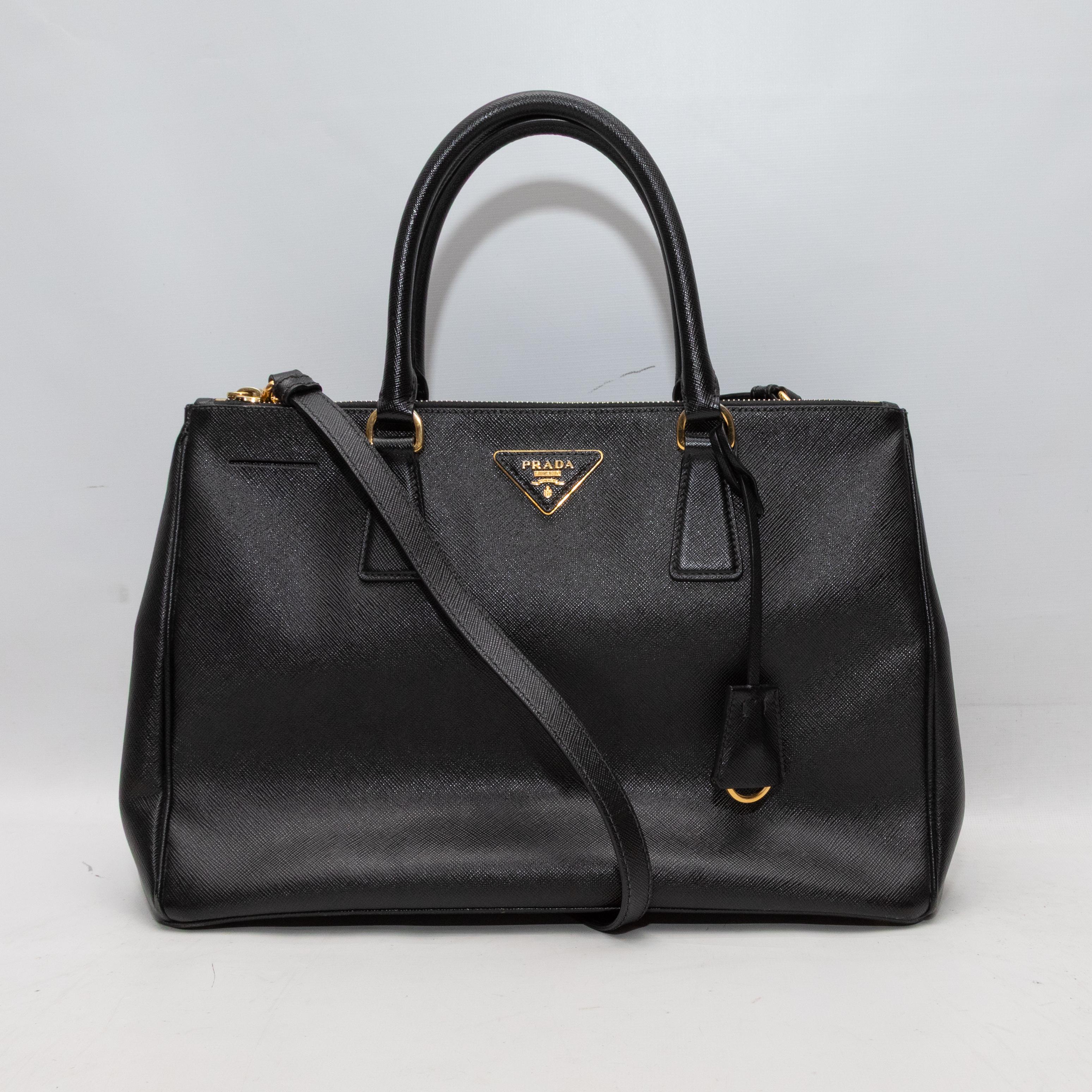 Black Prada Saffiano Neo Galleria Tote. The Neo Galleria Tote features a Saffiano leather body, gold-tone hardware, dual rolled top handles, a single shoulder strap, and a top zip closure. 13.5