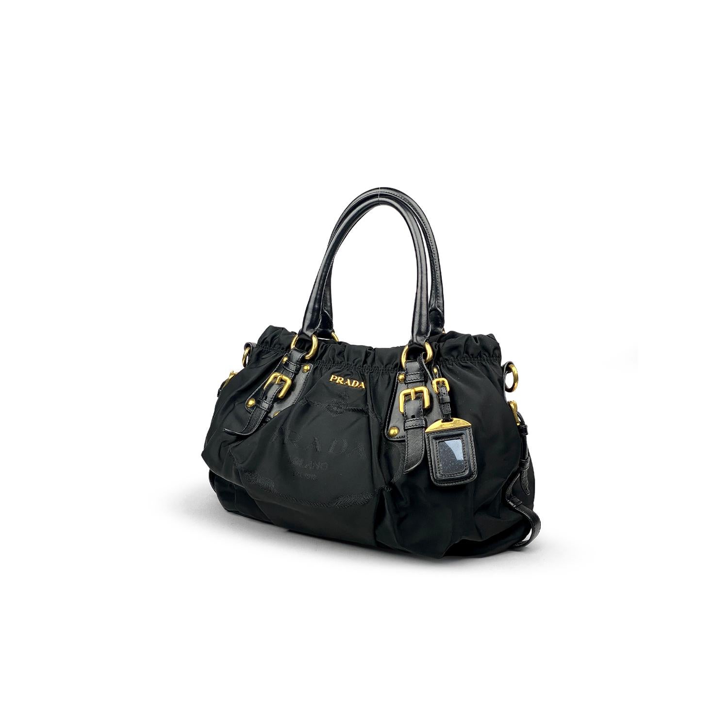 Black Tessuto nylon Prada satchel with 

- Gold-tone hardware
- Dual rolled handles
- Black leather trim
- Embroidered logo at front
- Black logo jacquard lining, dual interior pockets; one with zip closure and snap closure at top

Overall Preloved