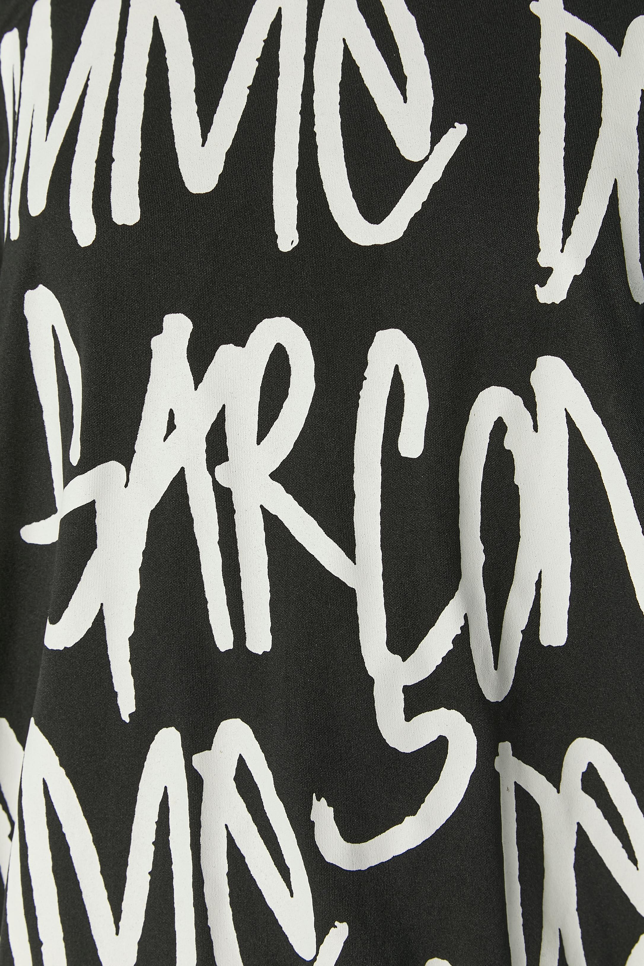 Tee-shirt noir imprimé avec un cercle rigide dans le bord inférieur qui le rend ondulé sur le bord. 
Composition du tissu principal : polyester
XS sur l'étiquette mais la taille est plutôt L. 