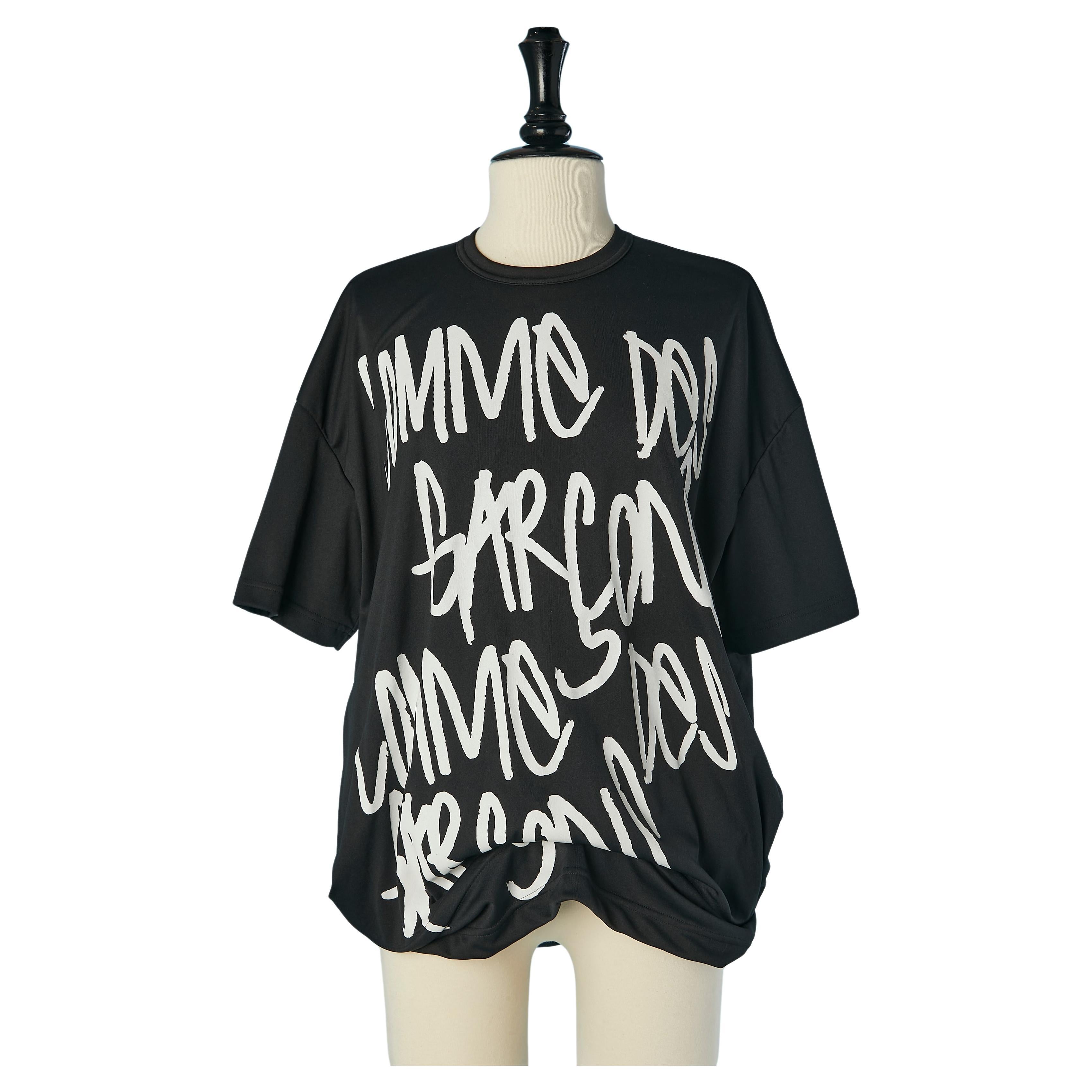 Tee-shirt noir imprimé avec un cercle rigide dans le bord inférieur Comm des Garçons