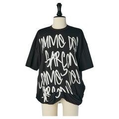 Schwarzes bedrucktes T-Shirt mit steifem Kreis am unteren Rand Comme des Garçons Shirt 