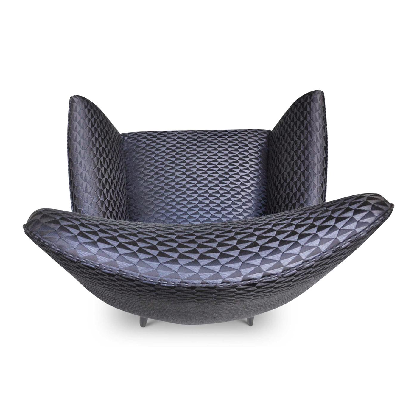 Black Raffia is a small stylish chair covered in a multifaceted geometric fabric on hand-turned wooden legs. Its slender and aggressive design make it a piece that will stand out. The item can be personalized and the chrome or brass nails that line