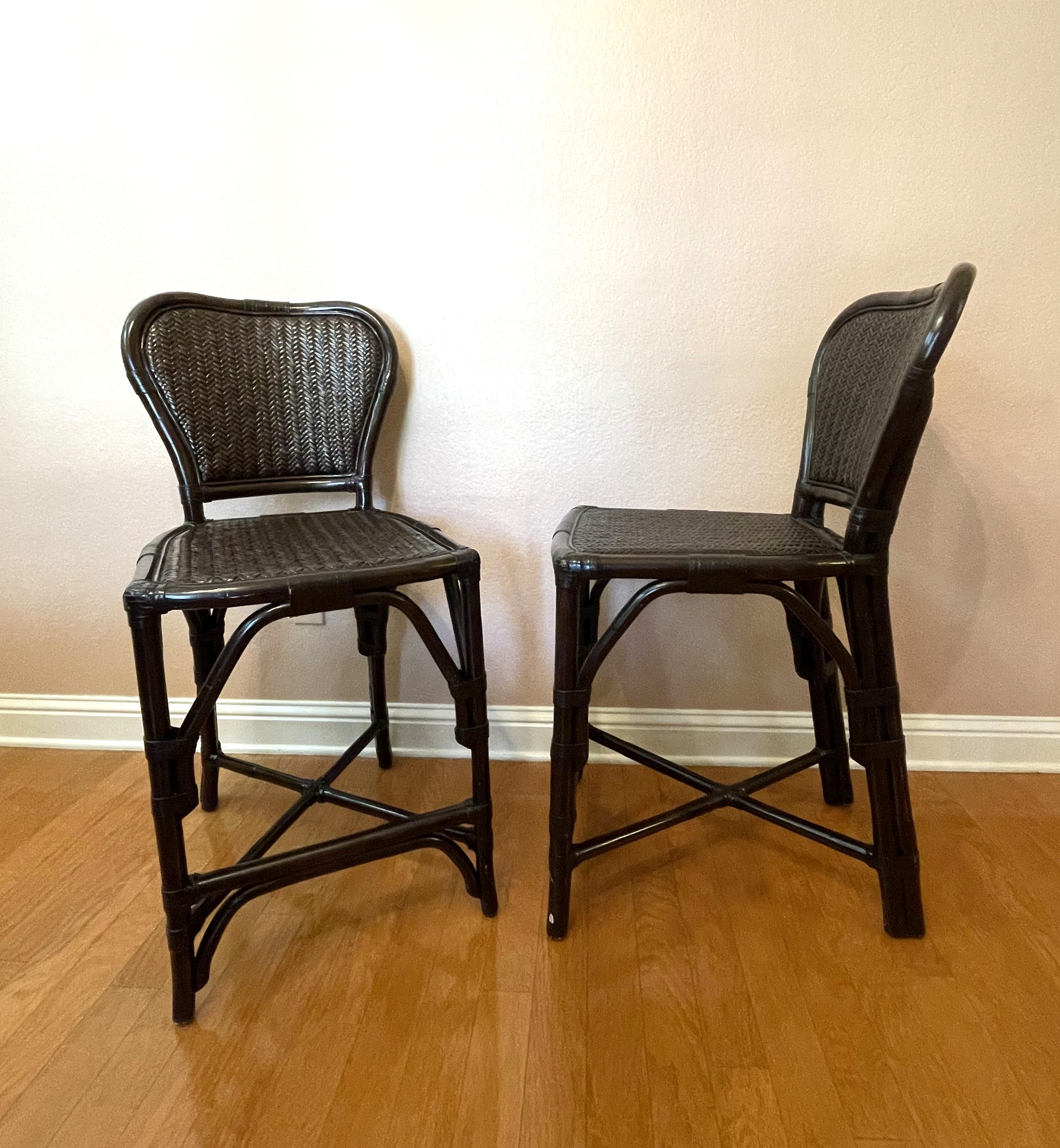 A pair of versatile black rattan and bamboo counter stools. Timeless lines -- they coordinate well in a traditional or contemporary interior. The black stain has a soft luster to it, which is very pleasing -- not harsh. The seat depth of 18