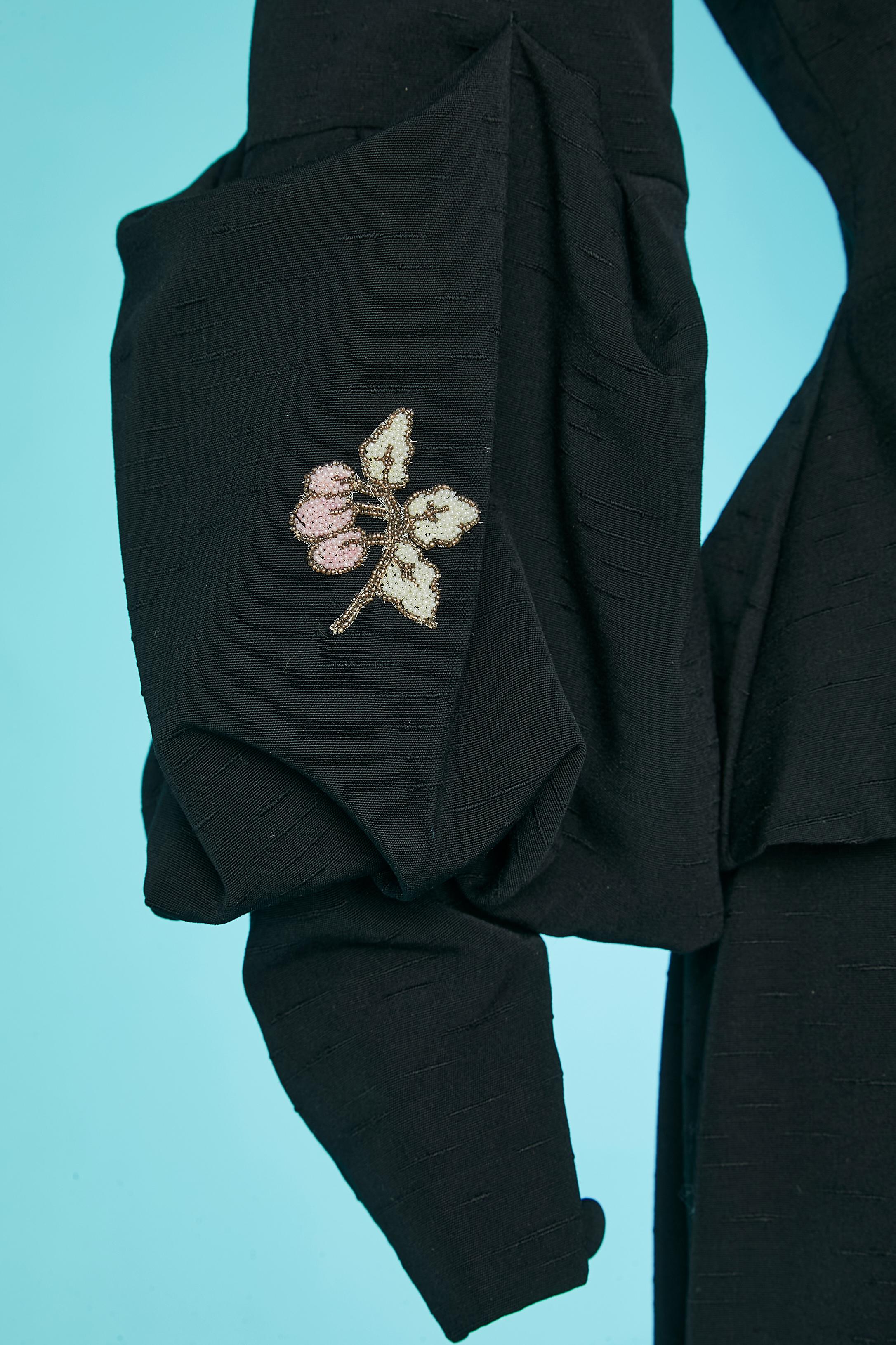Black raw silk ( French import fabric) skirt-suit with beadwork details on collar and bubbling sleeves. Rayon lining. Shoulder-pads. Fabric covered buttons and buttonhole. Buttons and buttonhole on cuff. Cut-work. 
SIZE S