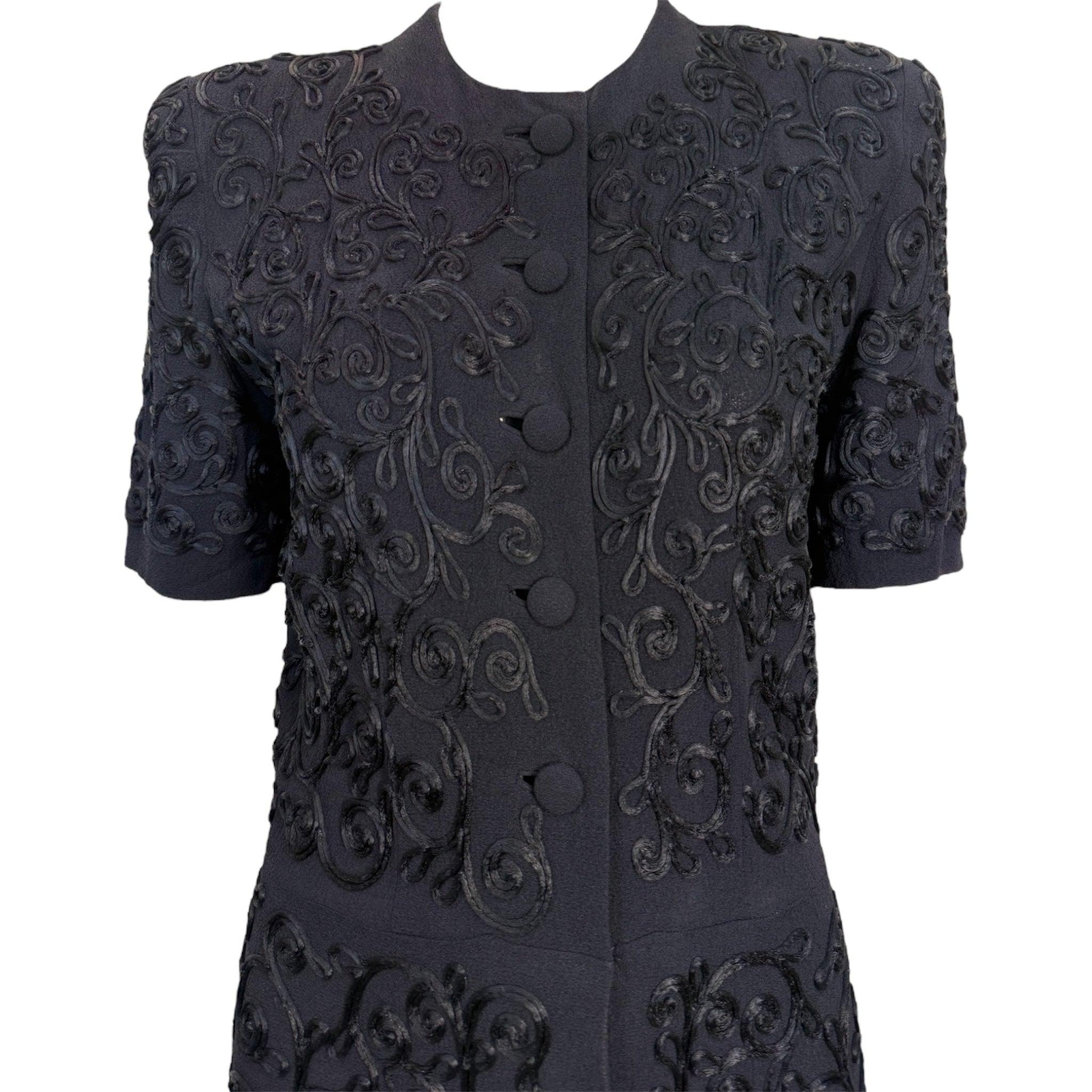 Classico abitino nero soutache anni '40. Sofisticata Silhouette strutturata ottenuta grazie alla spinta dei pad sulle spalle. Ci immaginiamo Lauren Bacall che lo indossa in una giornata cupa da qualche parte a Los Angeles in un film noir. Silhouette
