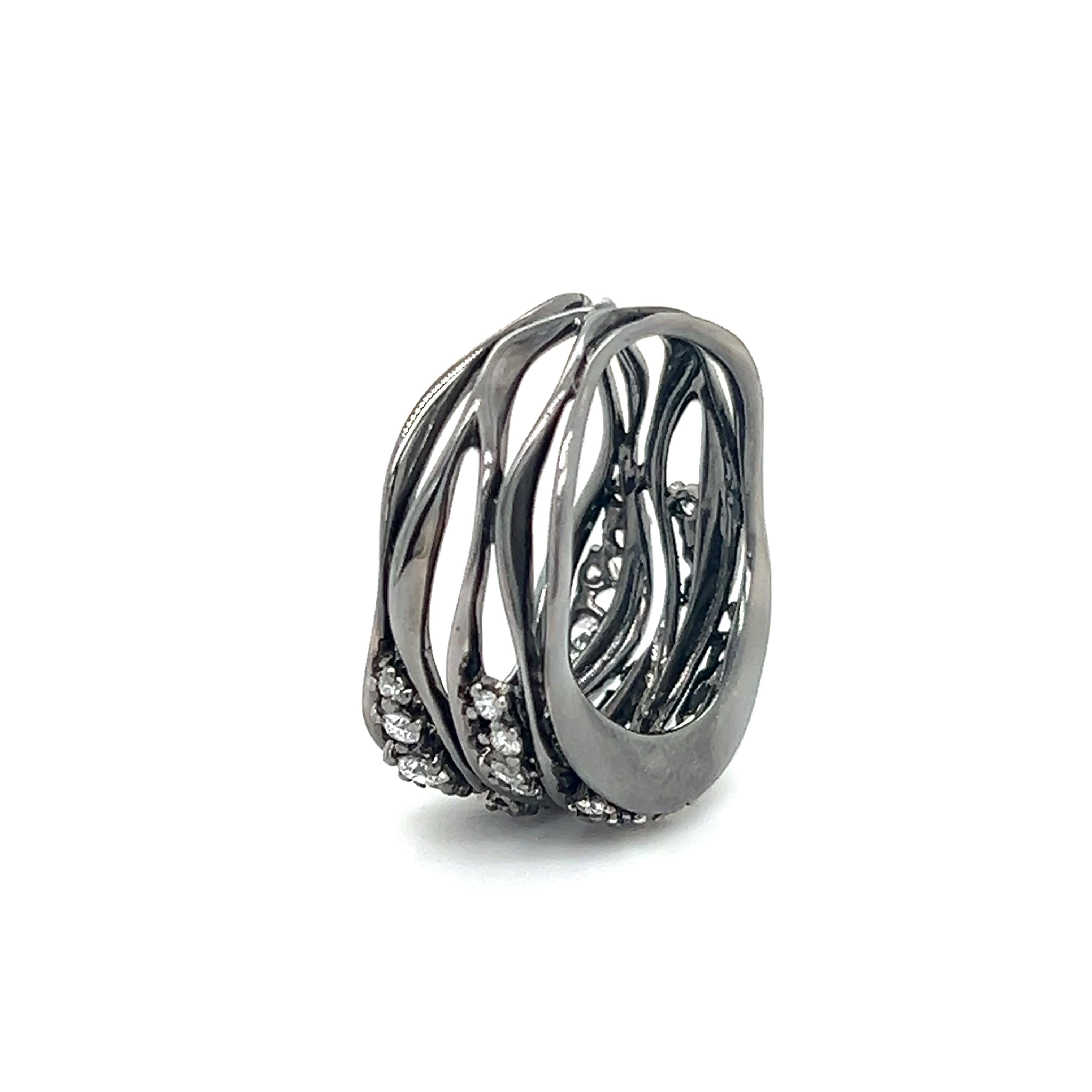 Gorgeous contemporary ring crafted in 18k. The ring is set with earth mined natural round diamonds in graduating sizes. The ring shows an amazing black rhodium finish that has an alluring appeal sure to be complimented whenever worn. 
The ring shows
