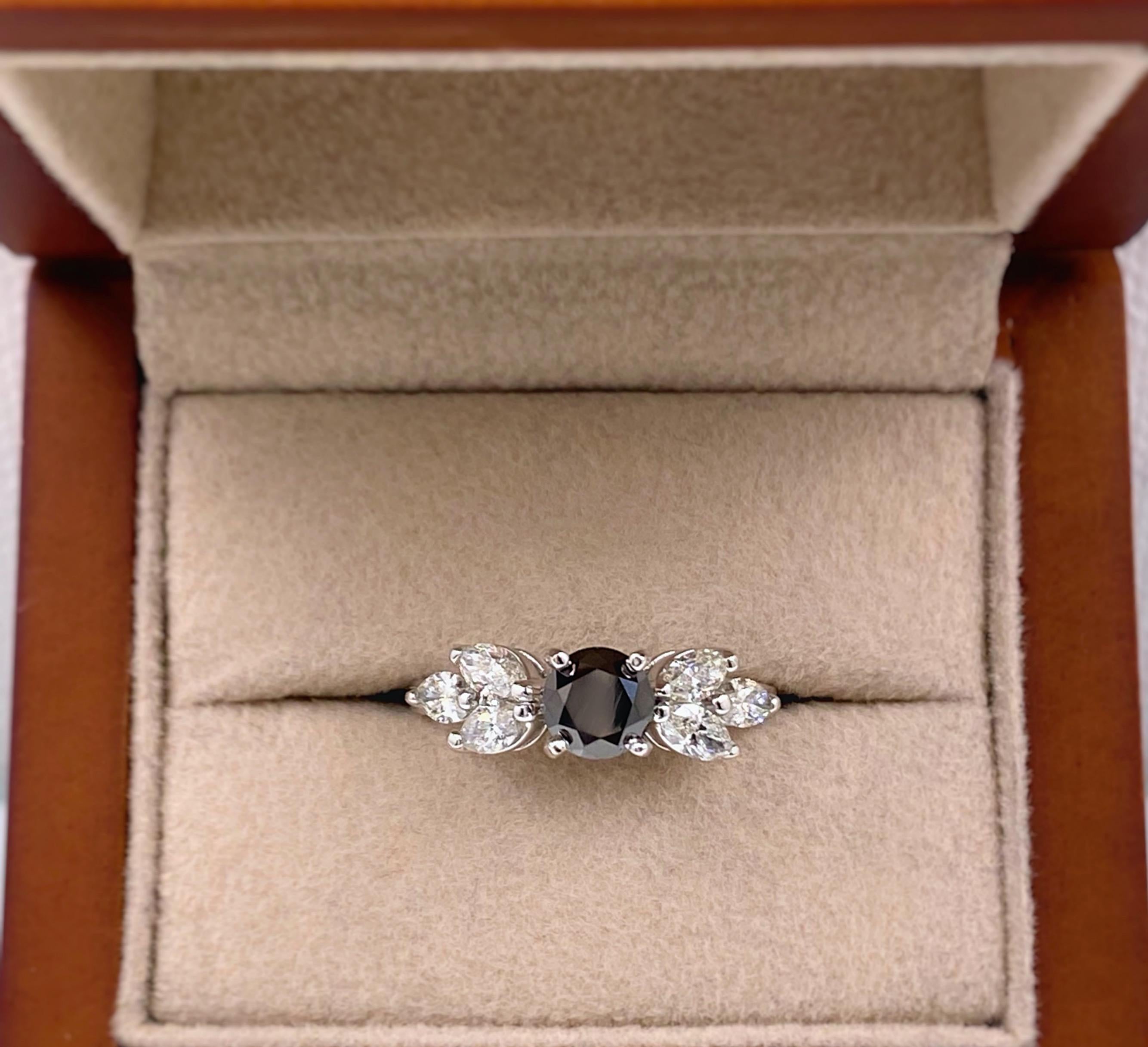 Black Round Diamond Engagement Ring
Style:  Solitaire with Accent Diamonds 
Metal:  14 kt White Gold
Size:  6 - Sizable
TCW:  1.40 tcw
Main Diamond:  Round Black Diamond 0.80 cts
Accent Diamonds:  6 Marquise Diamonds ( 3 on each side to mimic the