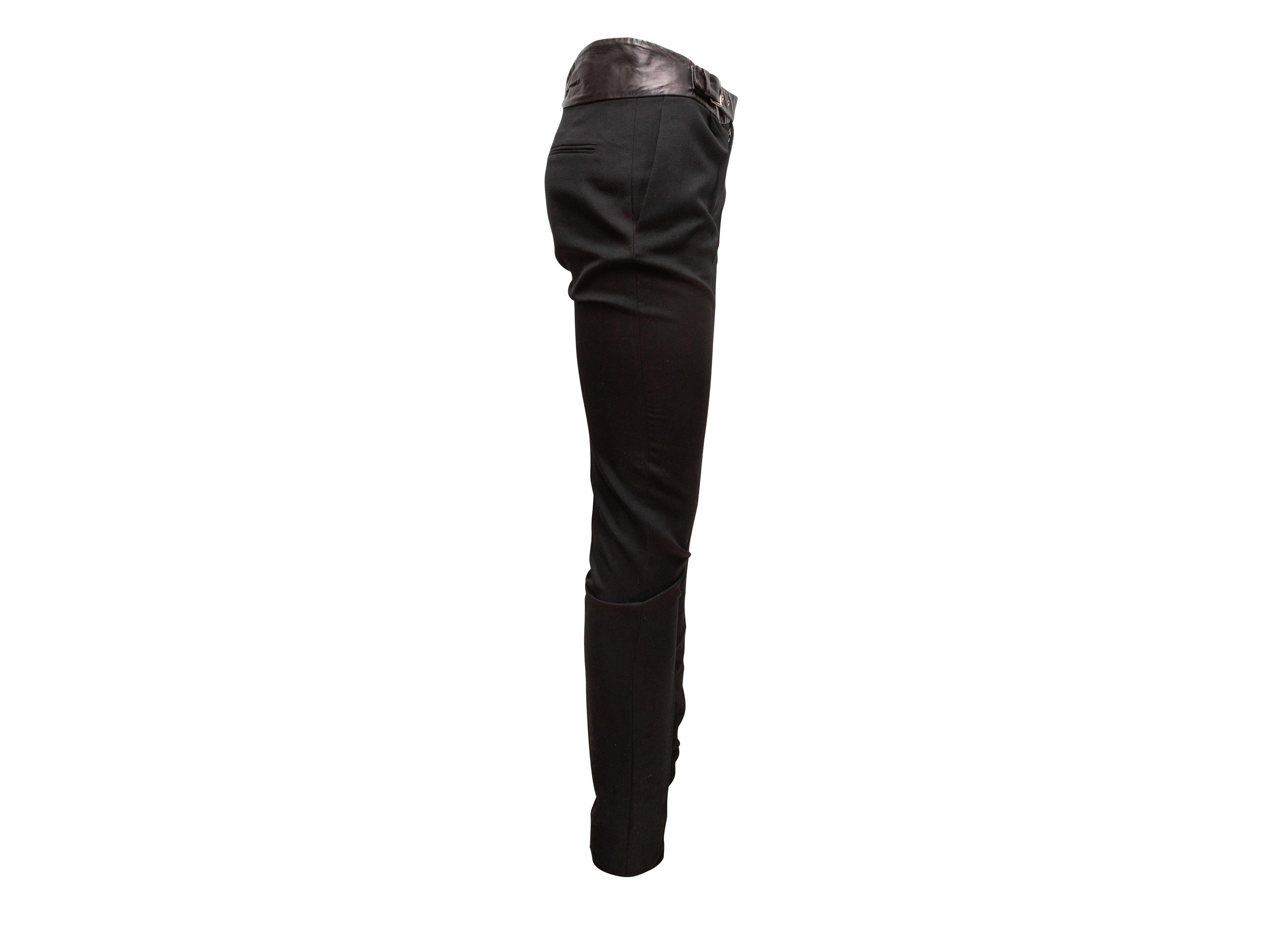 Black wool leather-trimmed skinny pants by Saint Laurent. Four pockets. Buckle closure at waist. 31