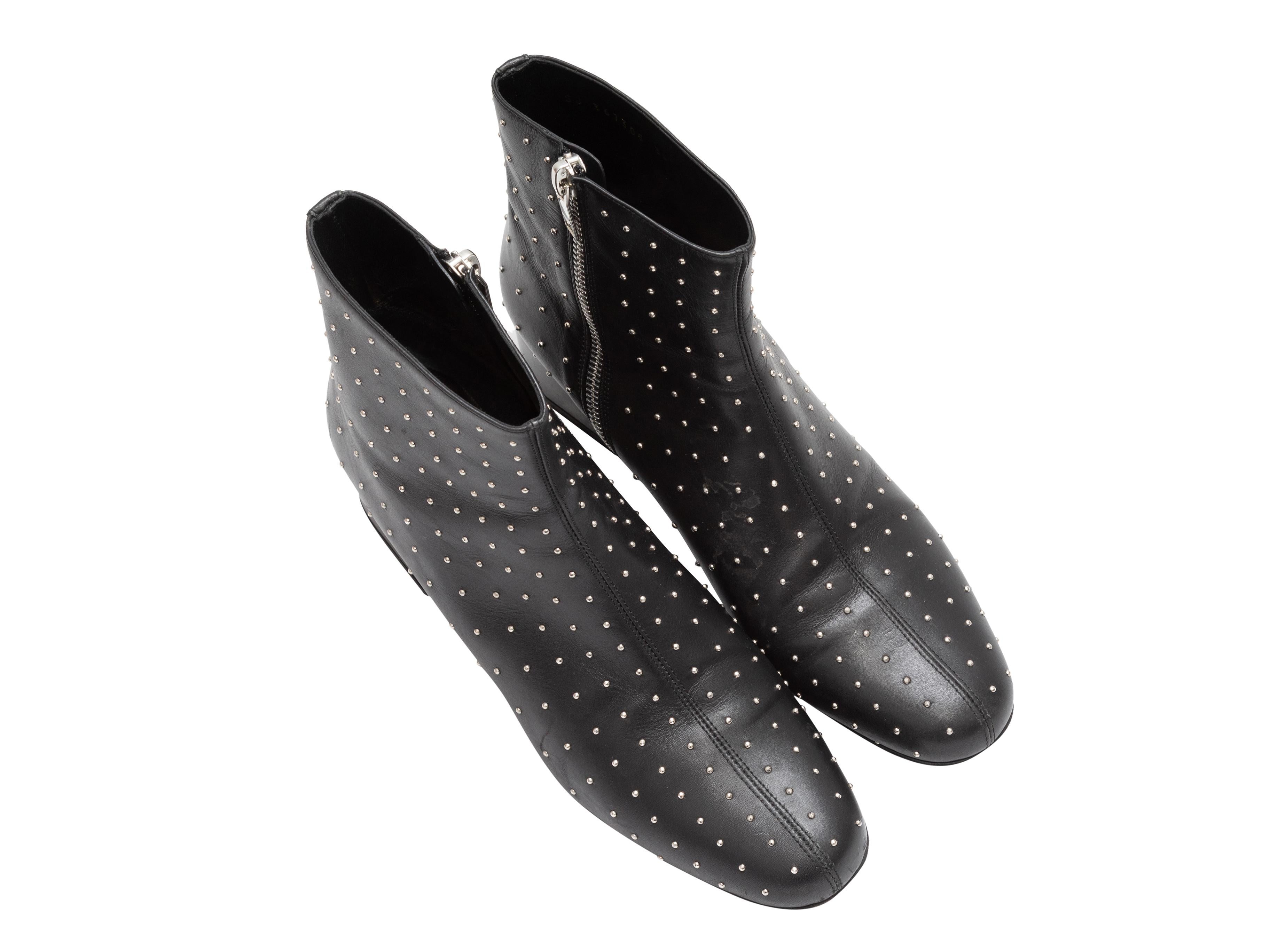 Black leather studded ankle boots by Saint Laurent. Silver-tone hardware. Block heels. Zip closures at inner sides. 5