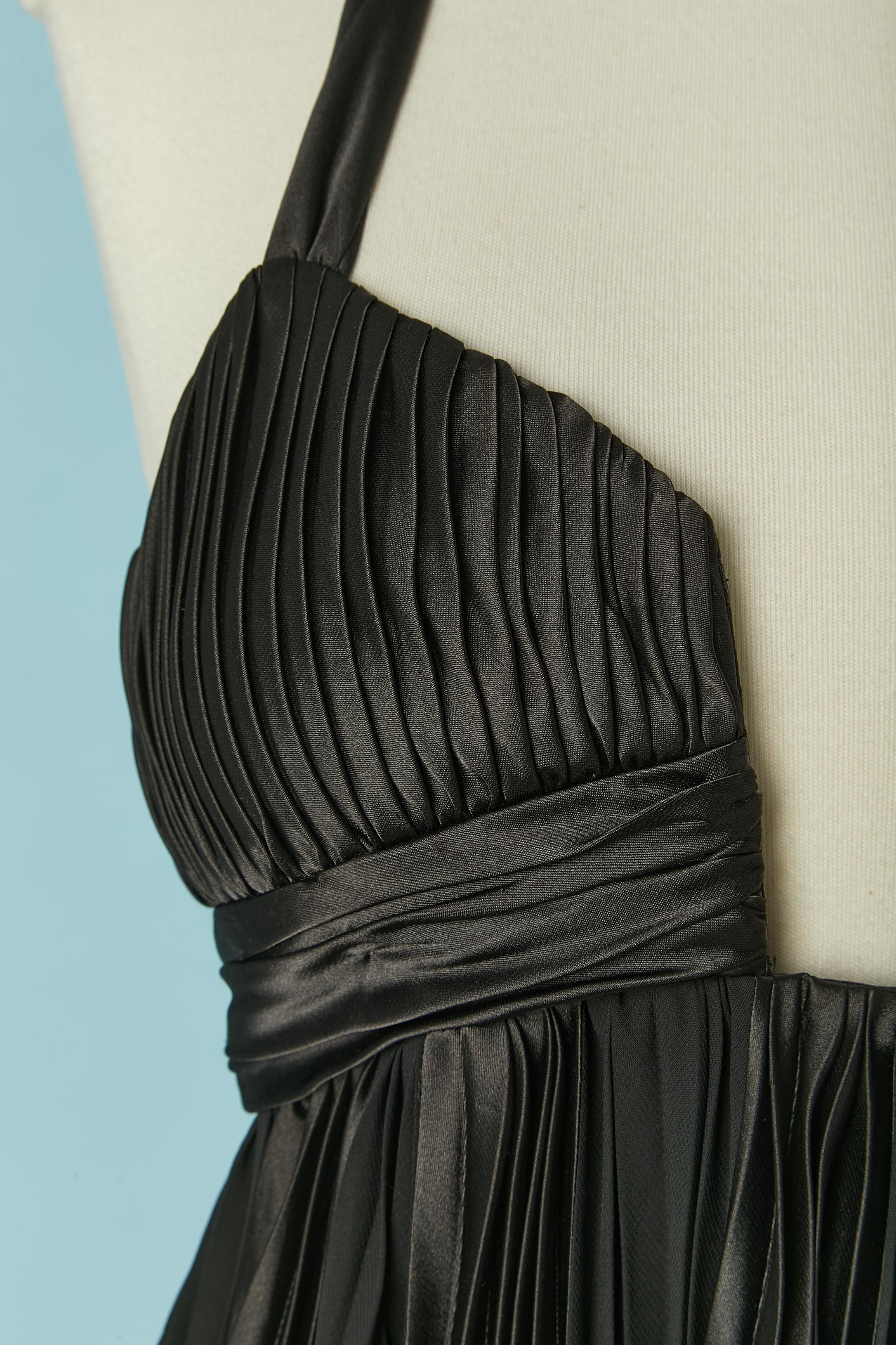 Vestido de cóctel negro de satén y gasa sin espalda y plisado. ( sin etiqueta de composición del tejido) 
Sujetador acolchado. Cremallera invisible y corchete en el lado izquierdo. El lazo debe atarse detrás del cuello. Borde de globo en la parte