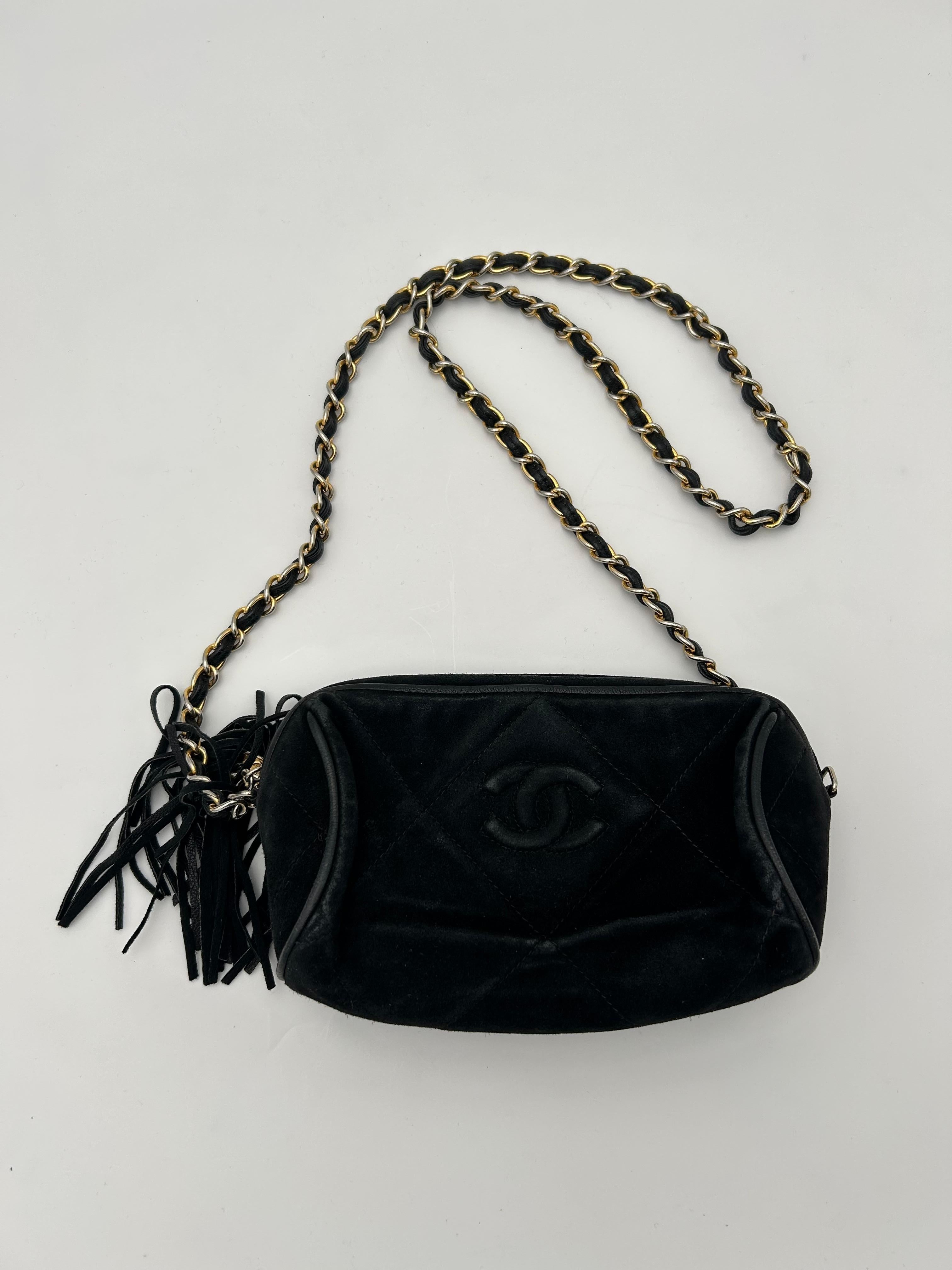 Die Vintage Black Nubuck Chanel Pompom Bag ist ein seltenes und skurriles Stück, das klassische Chanel-Eleganz mit verspieltem Charme verbindet und besonders bei Sammlern beliebt ist, die Chanel-Designs aus den 1980er bis 1990er Jahren unter Karl