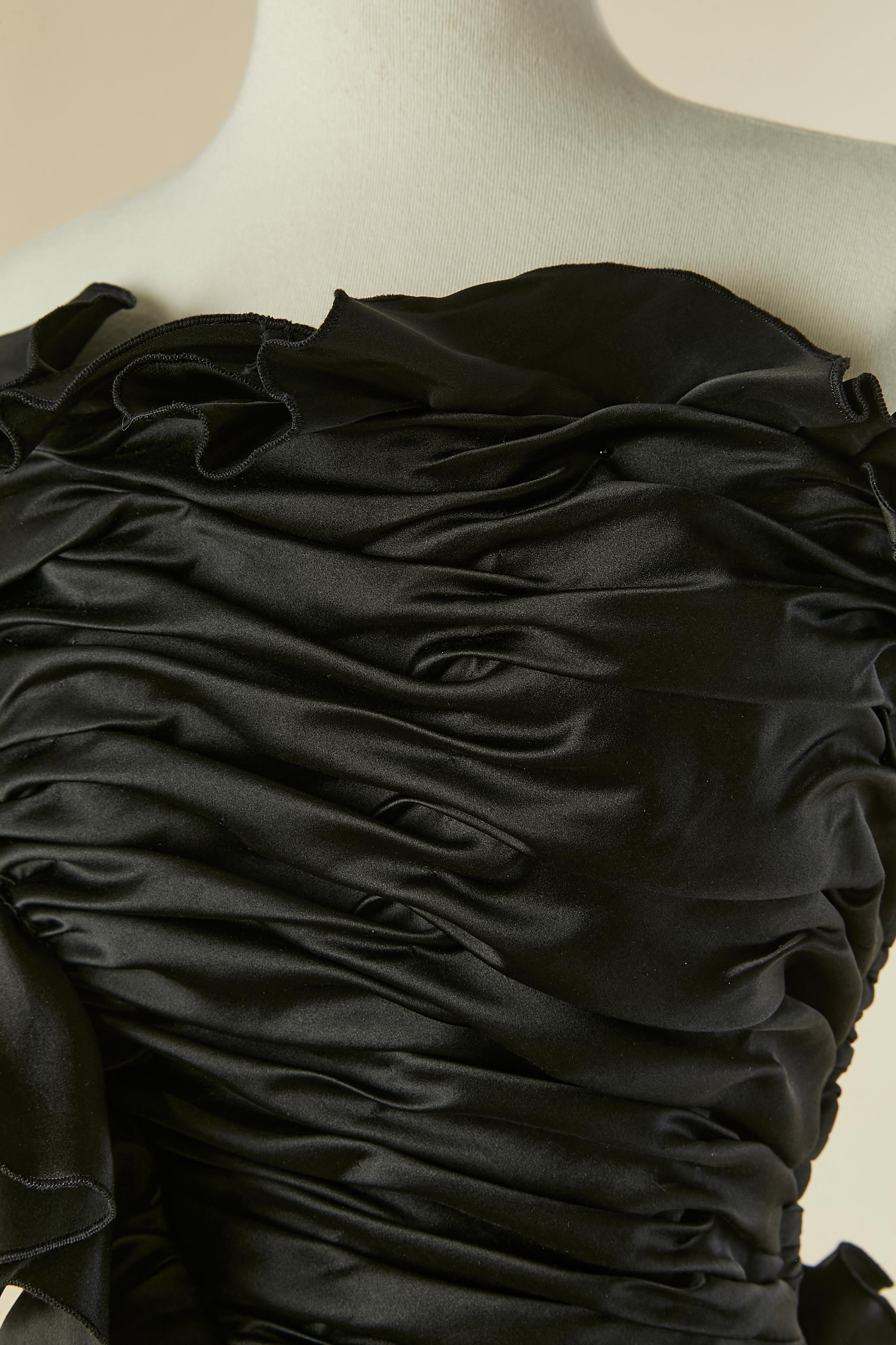 Robe de soirée à bustier drapé asymétrique en satin noir avec volants  Composition du tissu principal : 35% soie, 65% rayonne. Jupon en tulle et acétate. 
Bustier désossé. Fermeture à glissière sur la gauche + crochet et œillet. 
Longueur au milieu