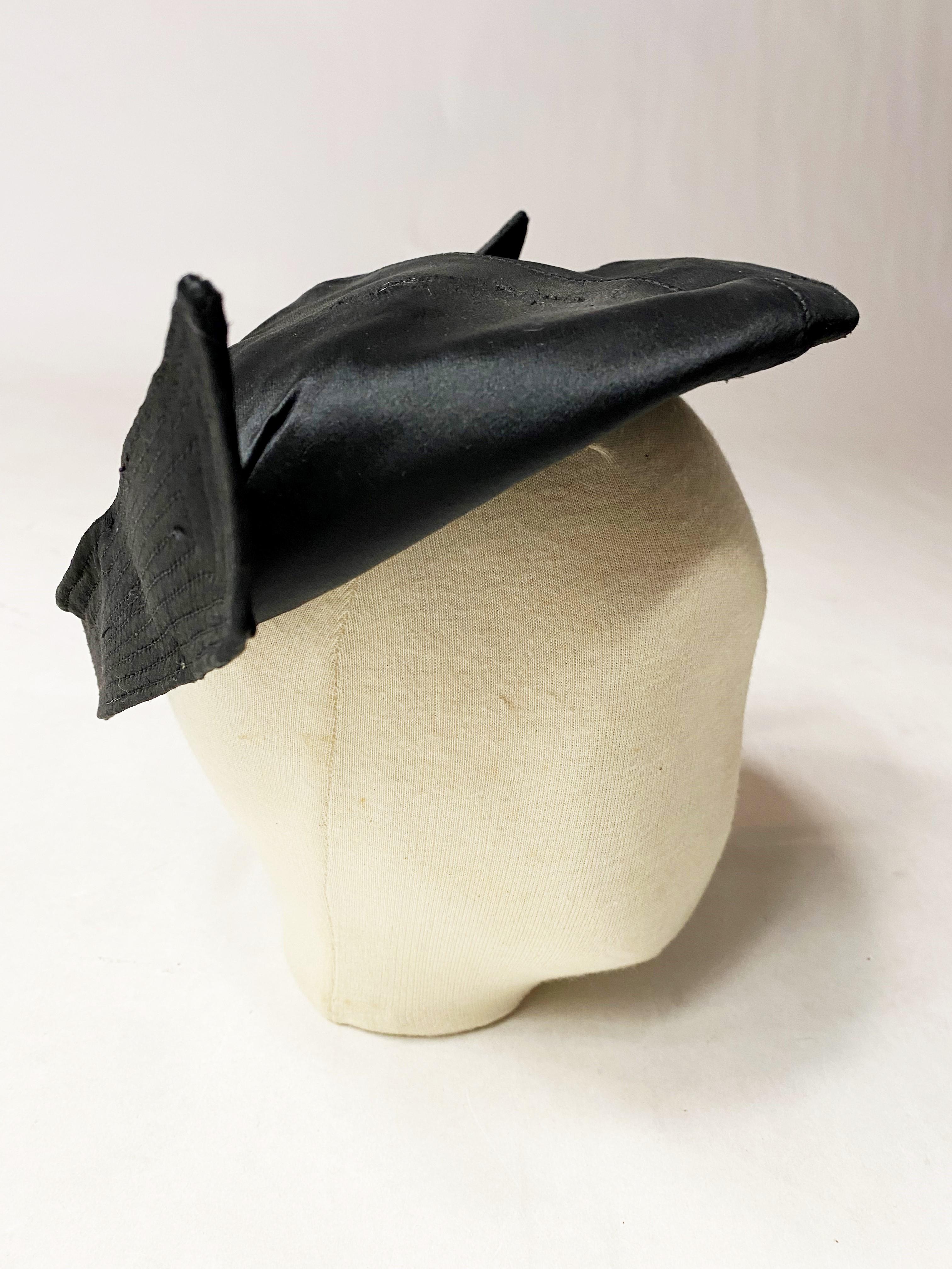 Circa 1945-1950

France

Elegant black satin beret bibi with stitched wings, signed Création Alberte Haute Mode Paris and dating from the late 1940s. Never used, it still has the sewn-in label of the shop. Stiff beret with tarlatan interlining,