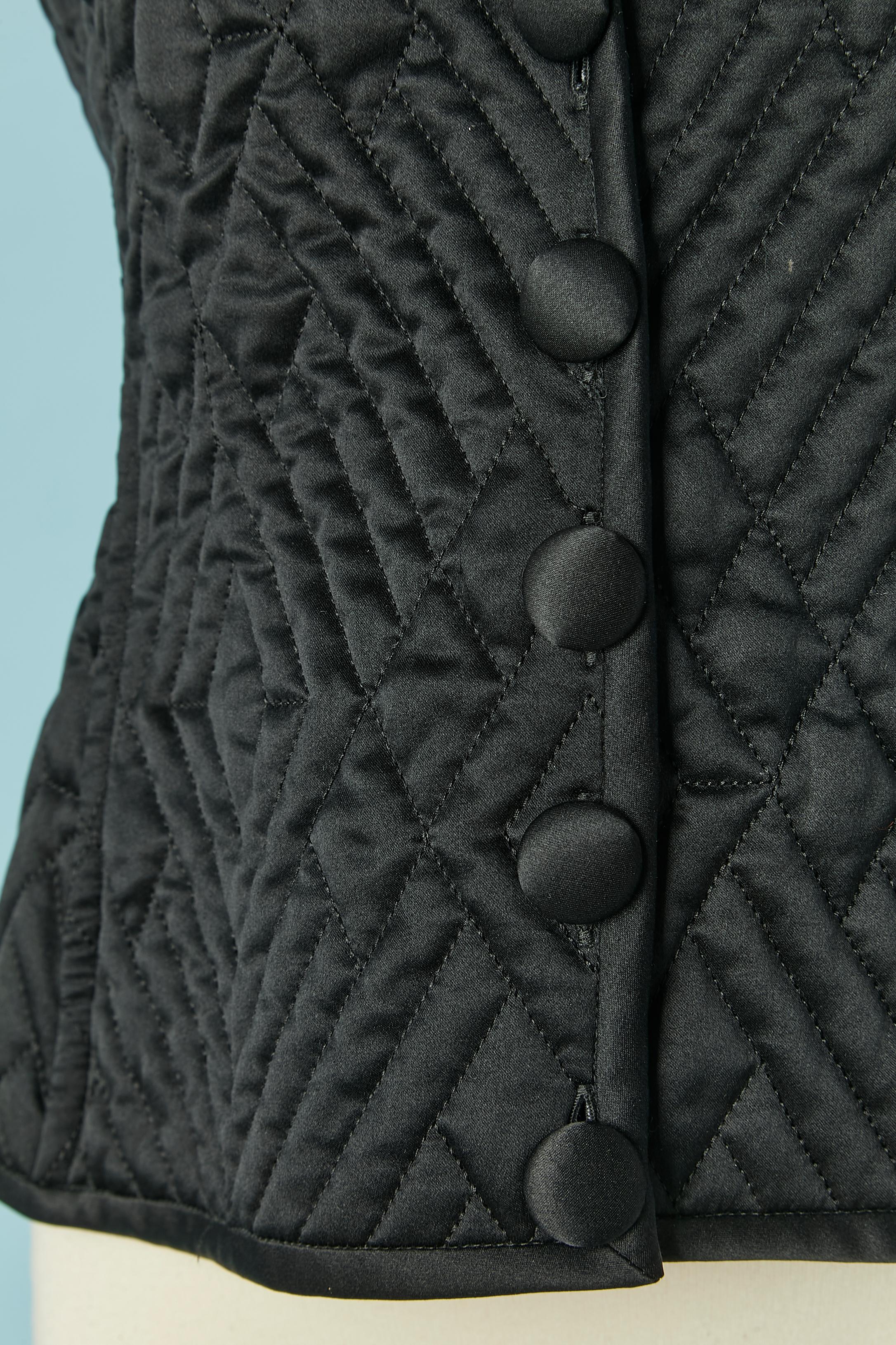 Black satin quilted vest with fur collar and fabric covered button. 
SIZE 6
