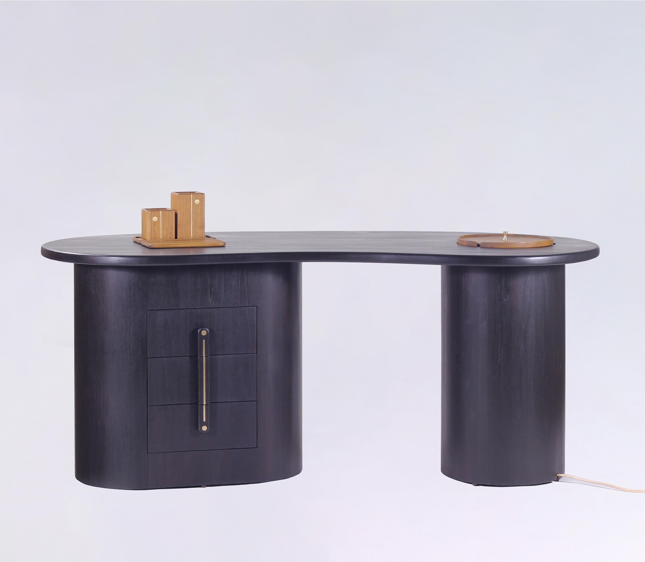 The Jazba work/writing desk table in solid Oak, is designed thoughtfully to address all the needs in your study/productive spaces. The organic kidney bean shaped top and cylindrical bases of the desk create a minimal yet sculptural aesthetic.